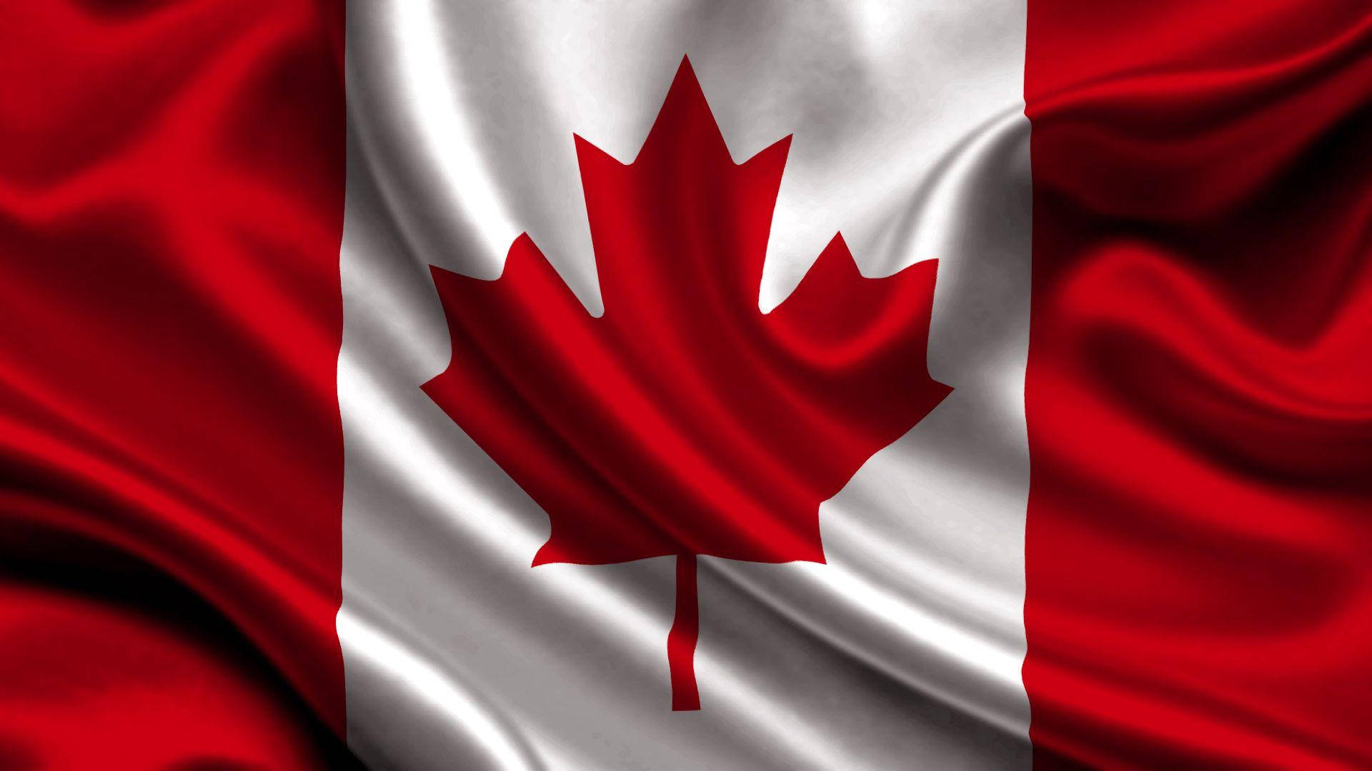 Canada Day 桌布 壁紙 — 加拿大國旗的特寫，紅色楓葉位於白色條紋中央，兩側為紅色區域，布料隨風飄動。