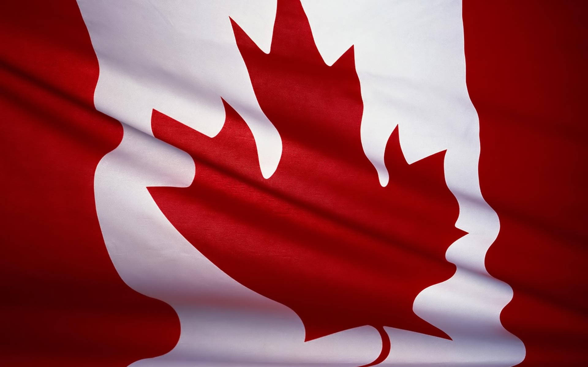 Canada Flag 桌布 壁紙 — 加拿大國旗近距離特寫，紅白布料褶皺在光線中飄揚。