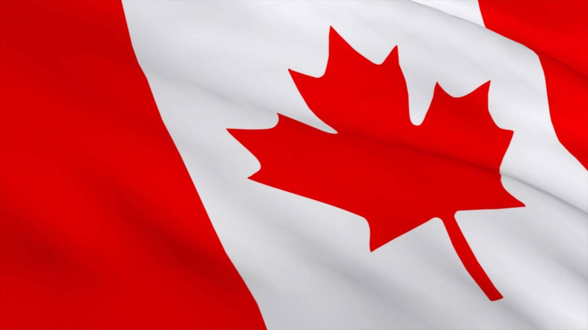 Canada Day 桌布 壁紙 — 加拿大國旗飄揚的近景，紅色和白色布料褶皺捕捉光線。