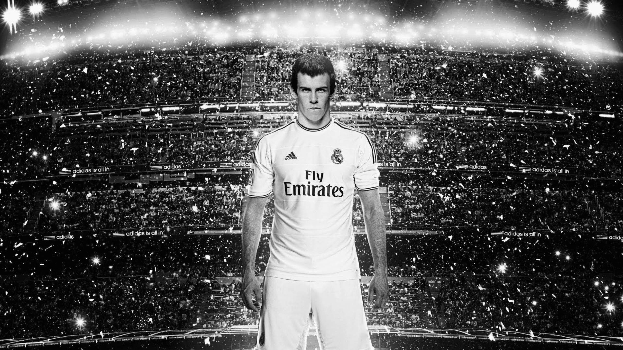 Gareth Bale 桌布 壁紙 — 加雷斯貝爾身穿皇家馬德里球衣，站在充滿紙屑和明亮燈光的球場中的黑白肖像。