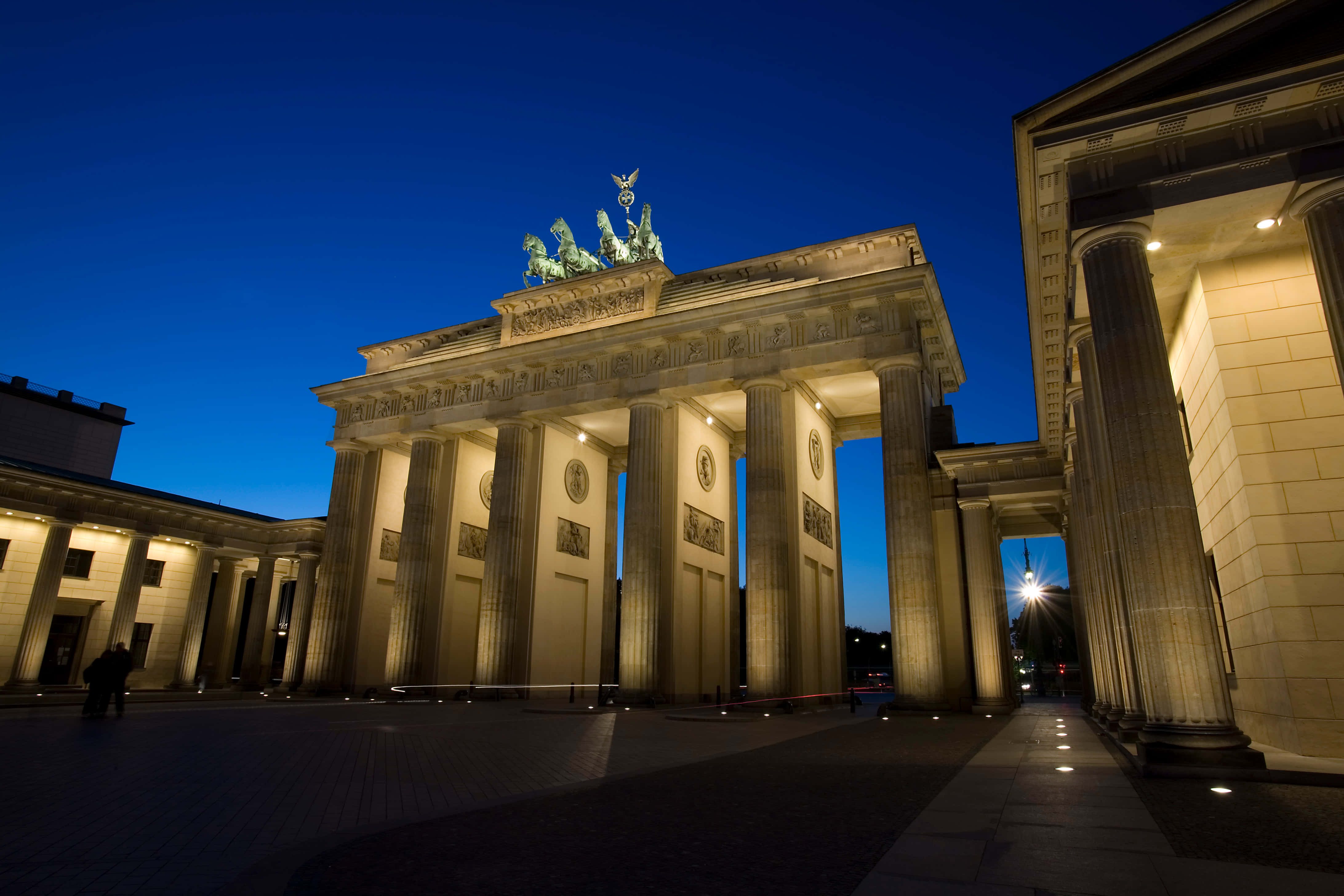 Berlin 桌布 壁紙 — 勃蘭登堡門在暮色中亮起溫暖的燈光，映襯著深藍色的天空。
