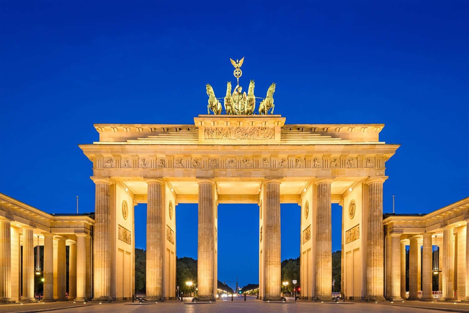 Berlin 桌布 壁紙 — 勃蘭登堡門在深藍色暮色天空的映襯下，散發著溫暖的金色光芒。