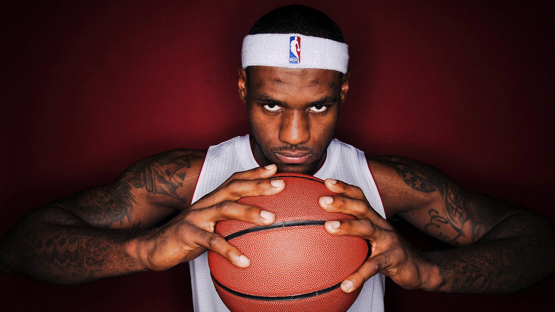 NBA 桌布 壁紙 — 勒布朗·詹姆斯在深紅色背景下，手持籃球，眼神專注。