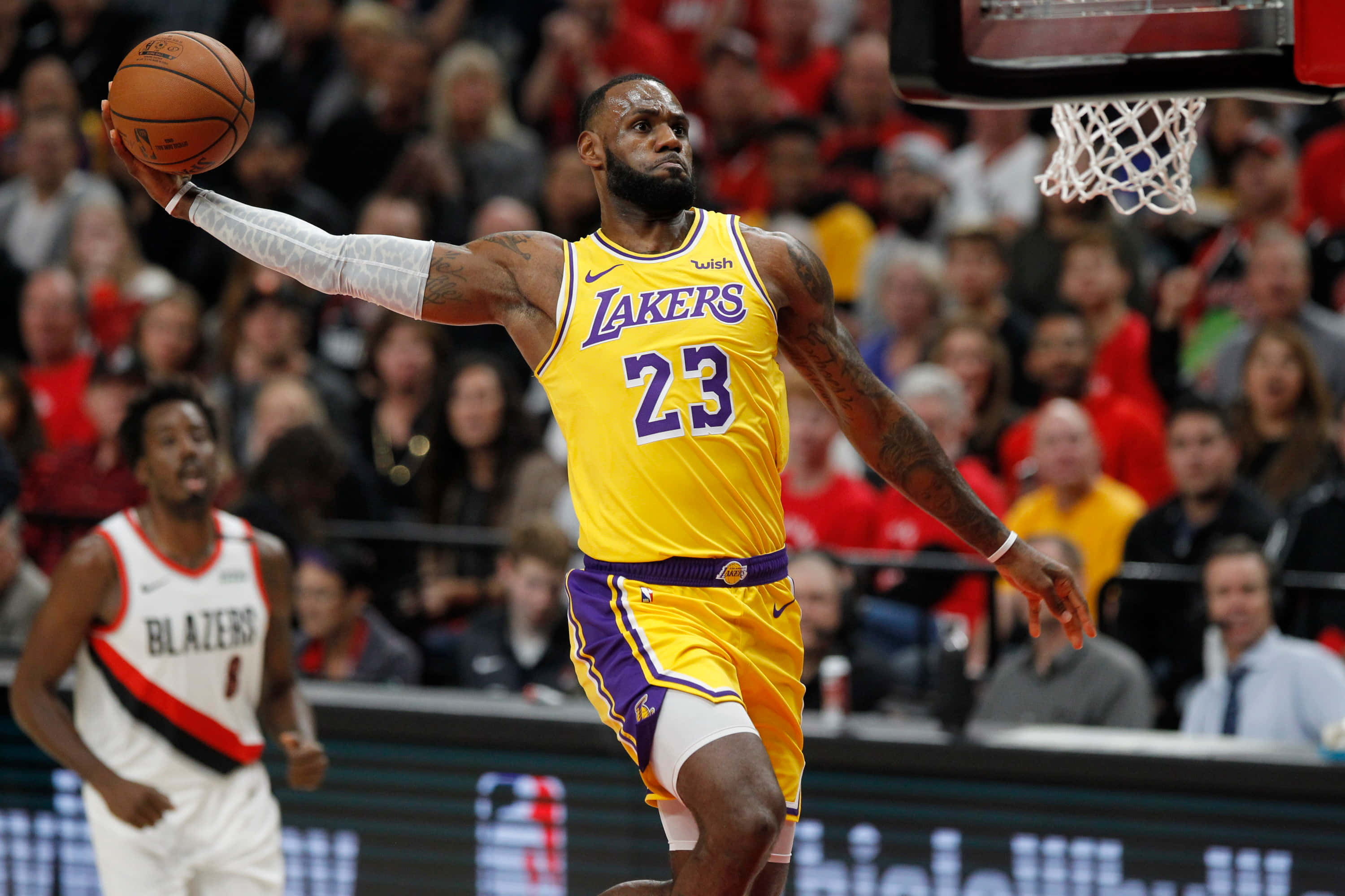 NBA 桌布 壁紙 — 勒布朗·詹姆斯穿著黃色湖人球衣，在明亮的場館燈光下，於激烈的NBA比賽中持球跳向籃框。