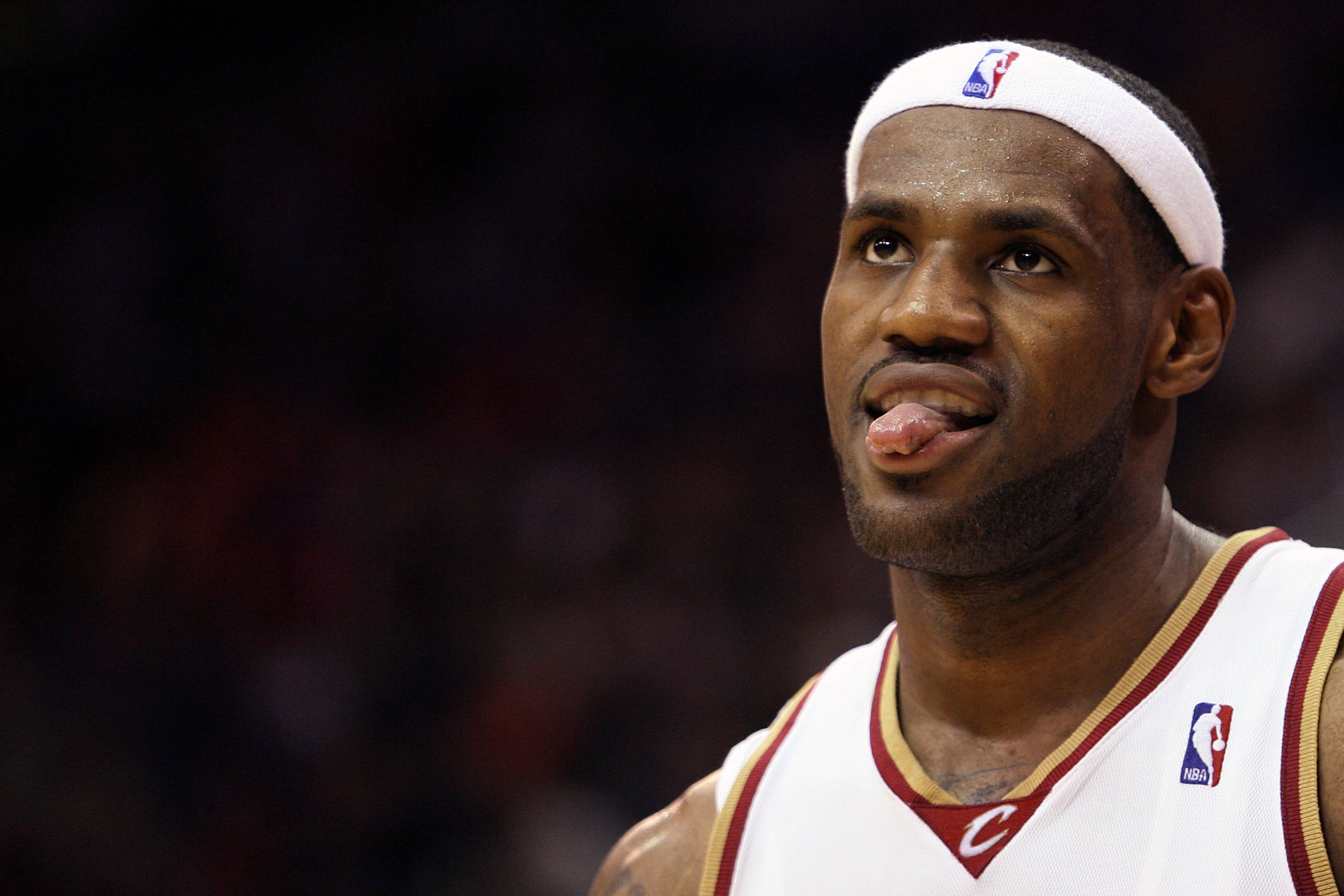 lebron james cool 桌布 壁紙 — 勒布朗·詹姆斯身穿克里夫蘭騎士隊球衣，在籃球比賽中專注地伸出舌頭。