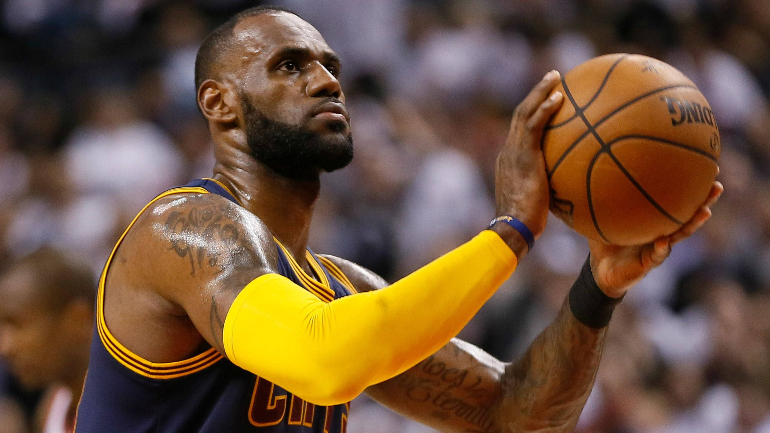 NBA 桌布 壁紙 — 勒布朗·詹姆斯身穿克里夫蘭騎士隊球衣，在明亮的場館燈光下於一場激烈的比賽中準備投籃。