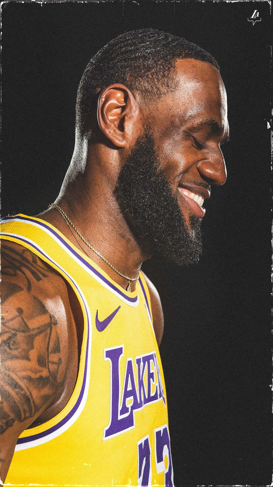 Lebron And Kobe 桌布 壁紙 — 勒布朗·詹姆斯身穿湖人球衣，在深色紋理背景前溫暖微笑，可見紋身和金鏈。