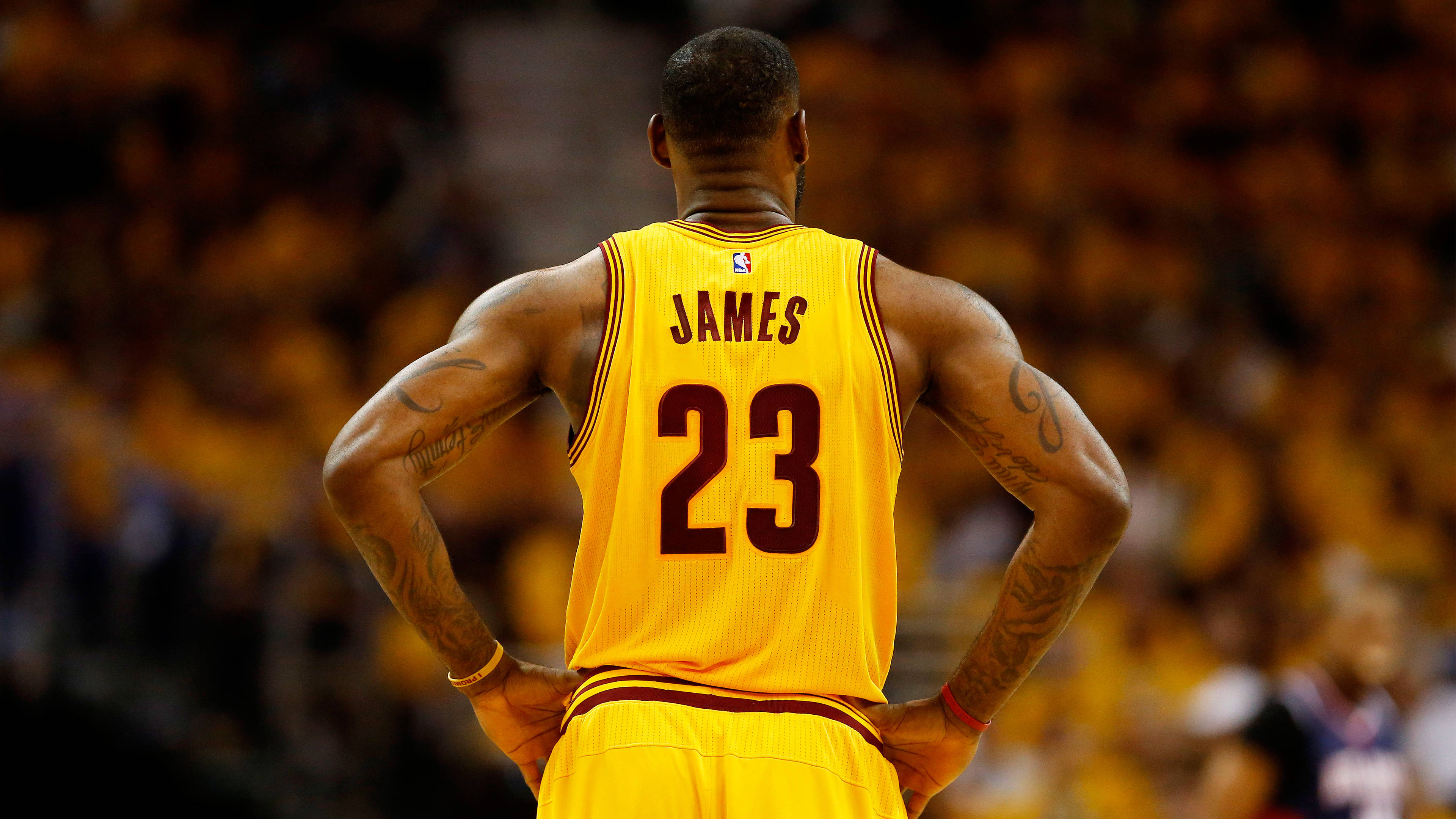 NBA 桌布 壁紙 — 勒布朗·詹姆斯身穿黃色23號球衣，雙手叉腰站在籃球場上的背面視角。