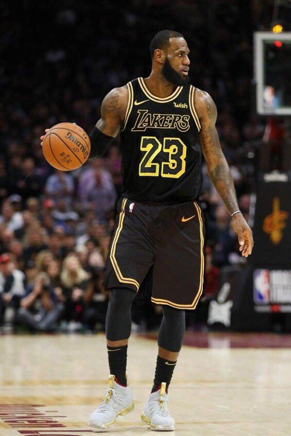 Lebron James Lakers 桌布 壁紙 — 勒布朗·詹姆斯身穿黑色湖人隊23號球衣，在場館燈光下比賽中運球。