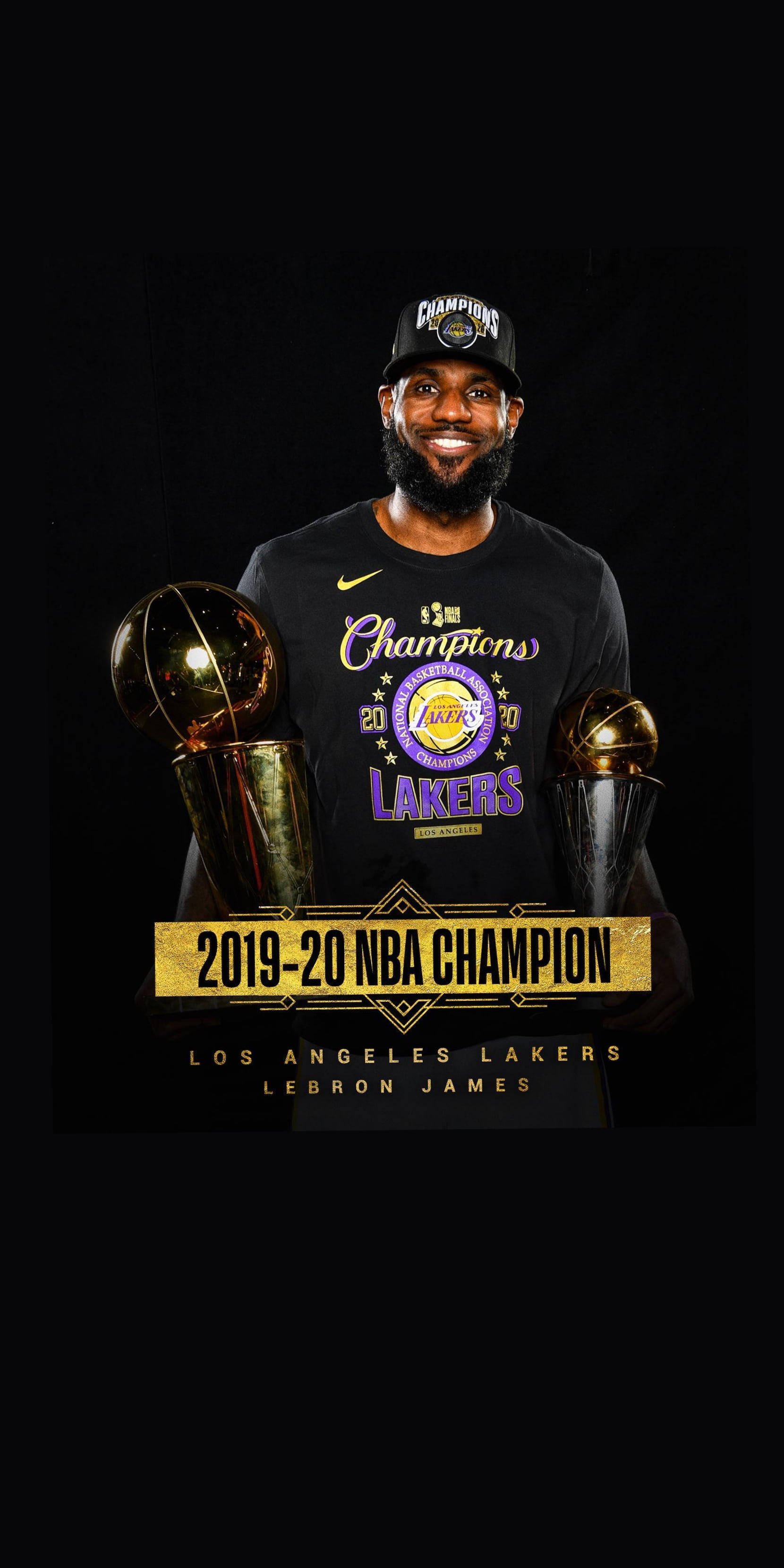 籃球 桌布 壁紙 — 勒布朗詹姆斯身穿『Champions』湖人T恤，在黑色背景前自豪地微笑，手持兩個NBA冠軍獎盃。