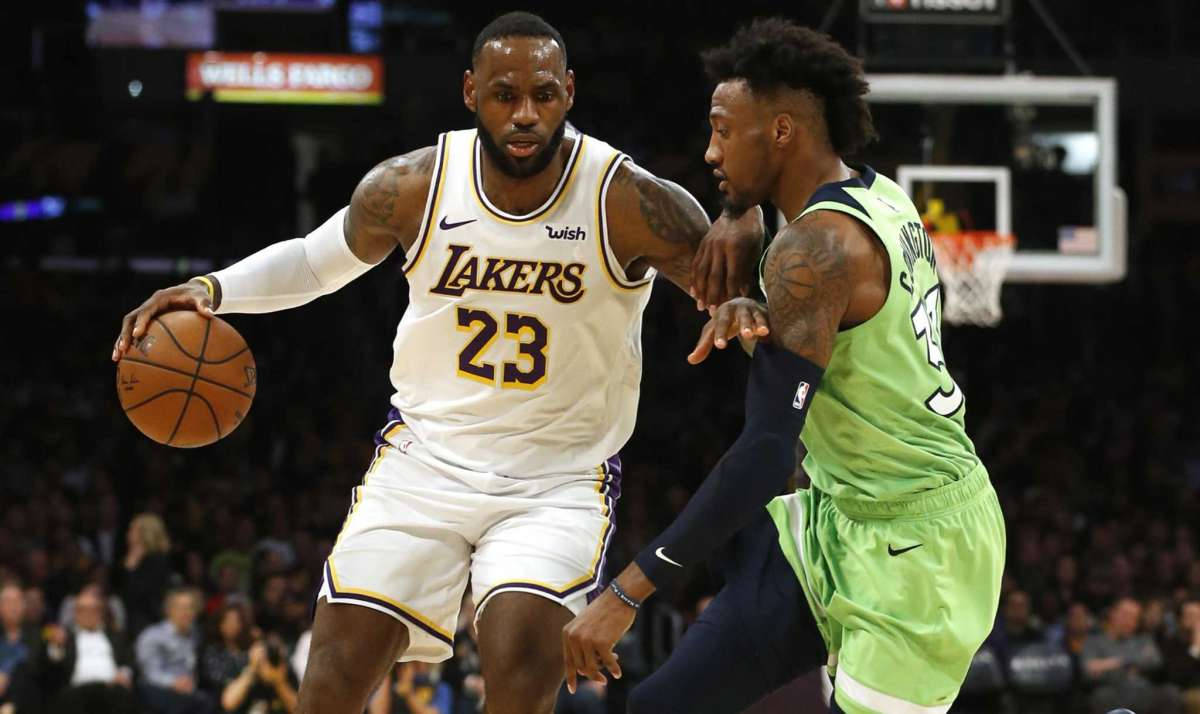 robert covington 桌布 壁紙 — 勒布朗詹姆斯身穿湖人球衣，在明亮的場館燈光下，於激烈的NBA比賽中突破防守球員。