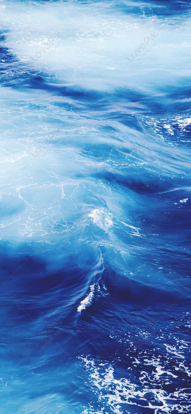 Wave 桌布 壁紙 — 動態海洋波浪在明亮陽光下翻湧，呈現深藍色和泡沫般的白色浪尖。