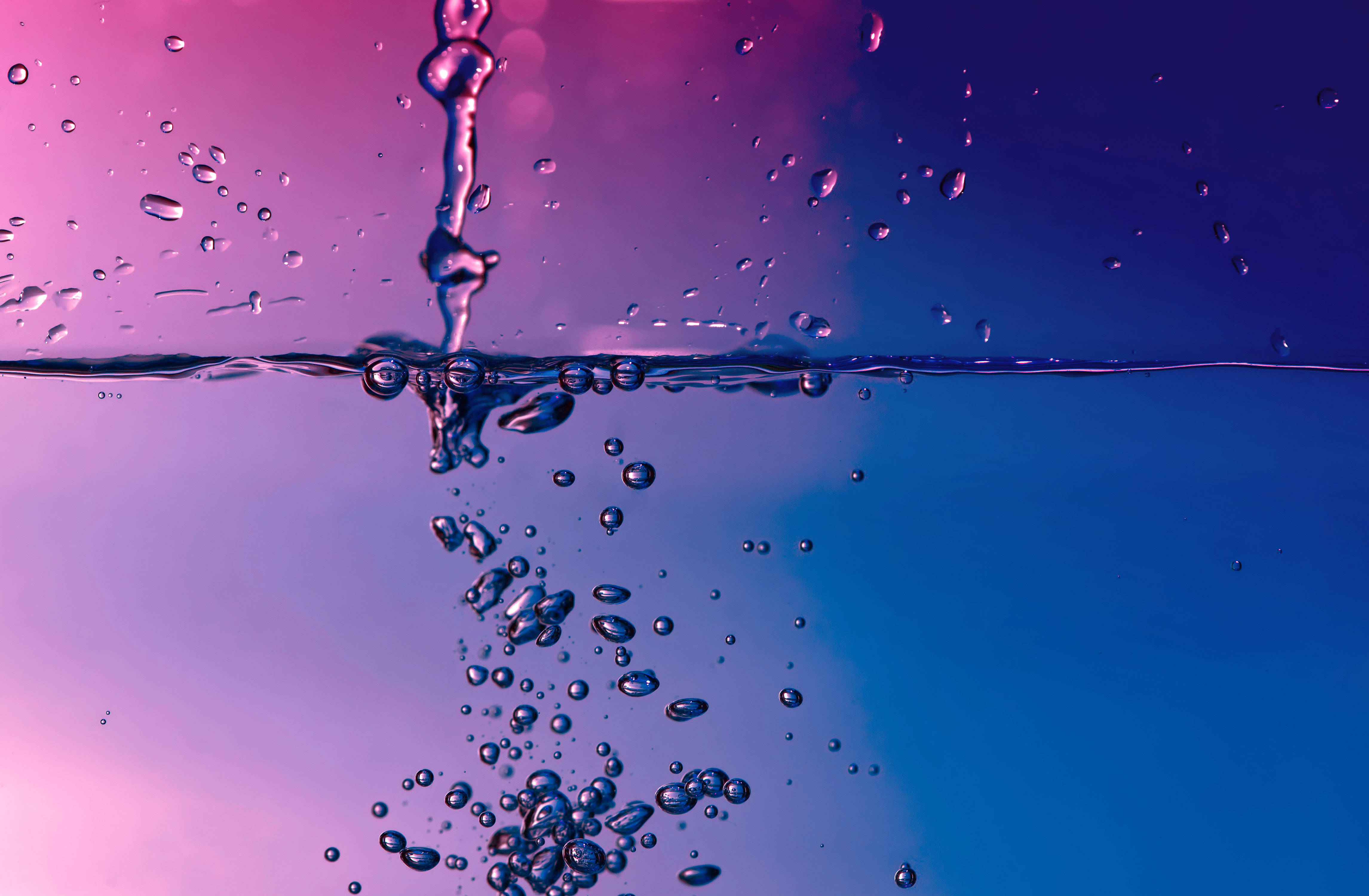 水 桌布 壁紙 — 動態的水花在漸變紫色和藍色背景上產生氣泡和水滴。