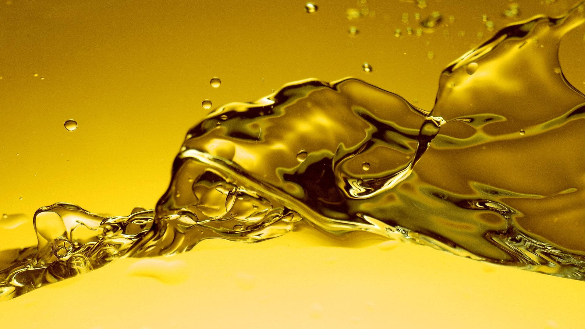 Oil 桌布 壁紙 — 動態金色液體流動，帶有光澤曲線和浮動氣泡，背景為溫暖的黃色漸變。