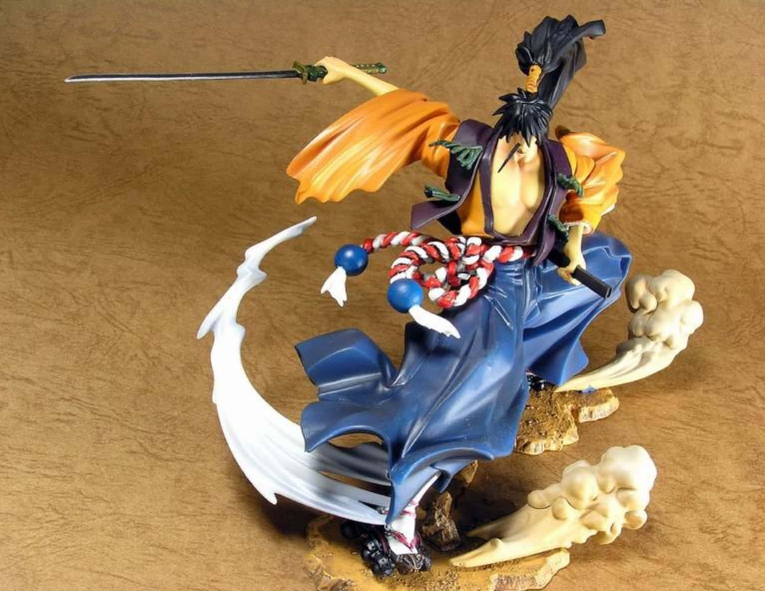 Rai-dei The Blade 桌布 壁紙 — 動漫劍客動態人偶，身穿飄逸的橙色和藍色長袍，背景為紋理棕色背景。