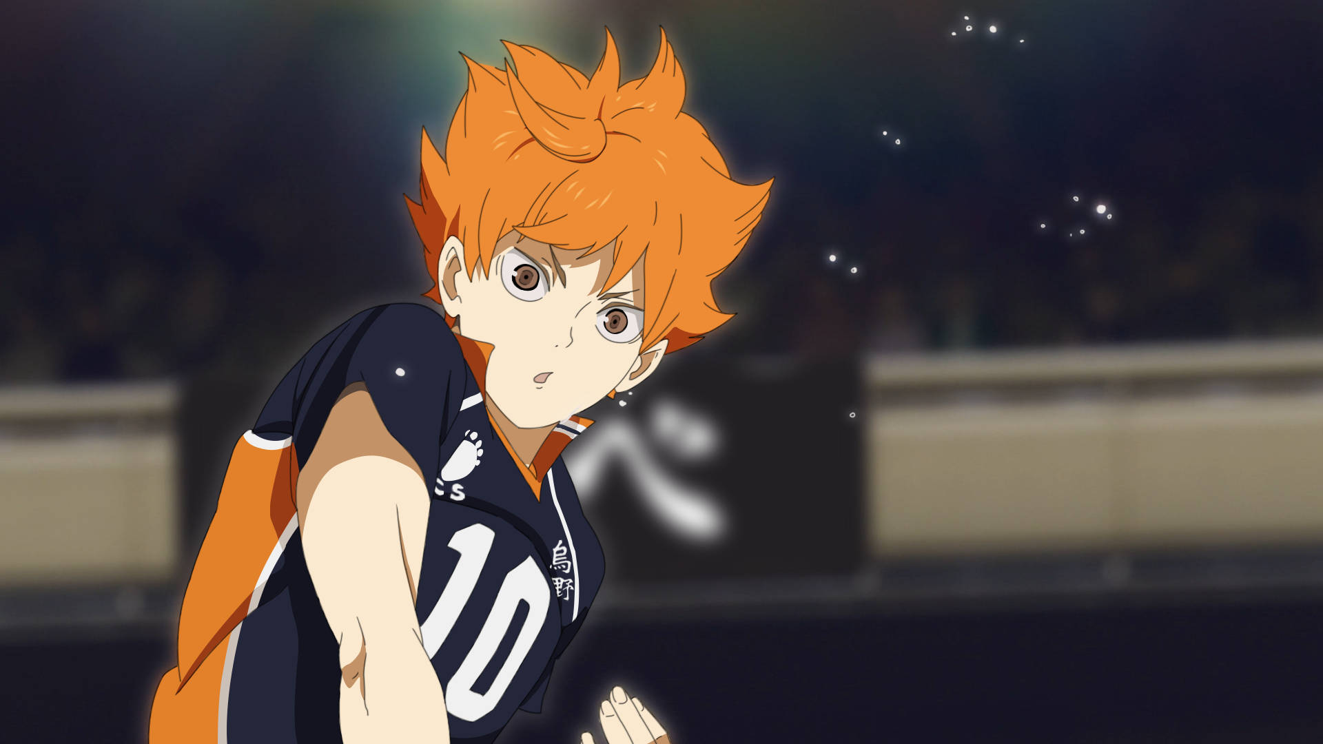 Shoyo Hinata 桌布 壁紙 — 動漫排球運動員，擁有尖刺的橙色頭髮，身穿深藍色和橙色球衣，在體育場燈光下於球場上激烈蹲伏。
