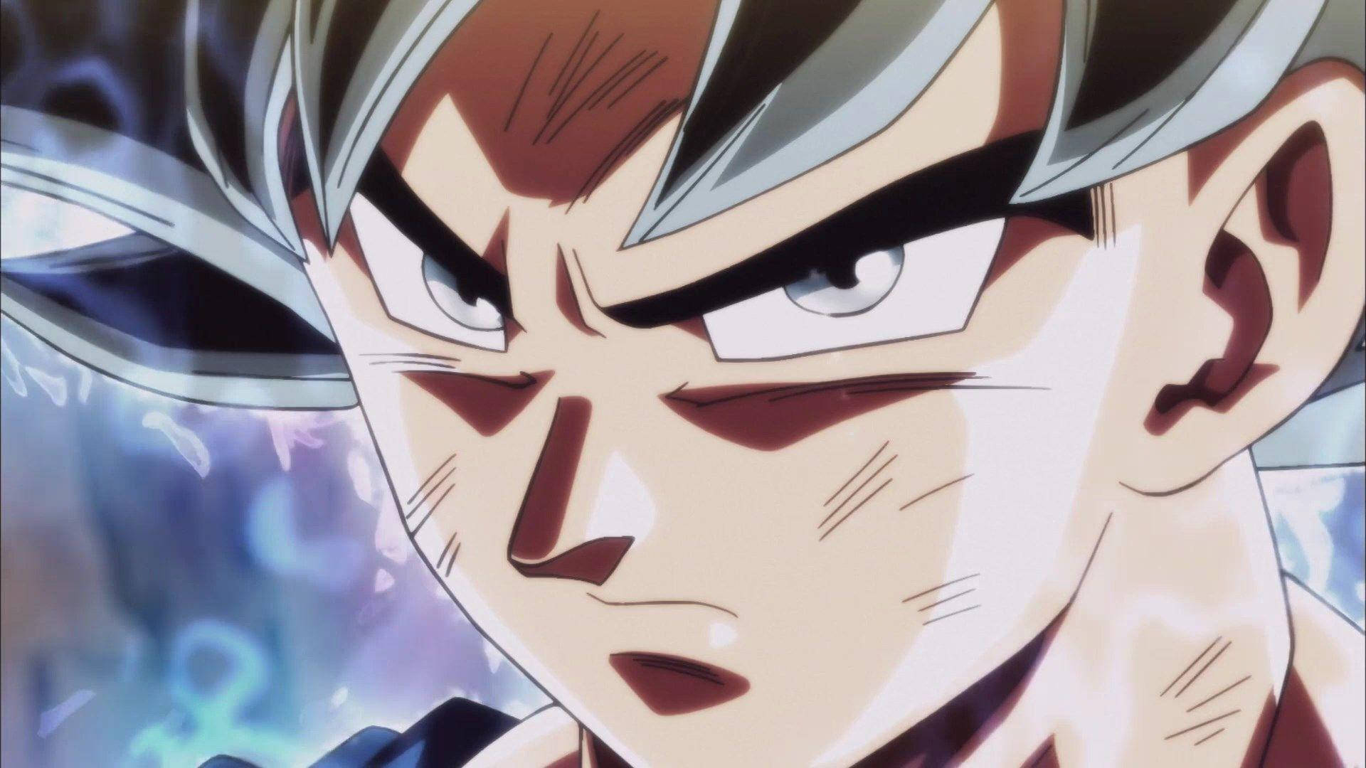 Ultra Instinct Goku 桌布 壁紙 — 動漫角色特寫，銀色頭髮，眼睛散發出強烈的藍色能量光芒。