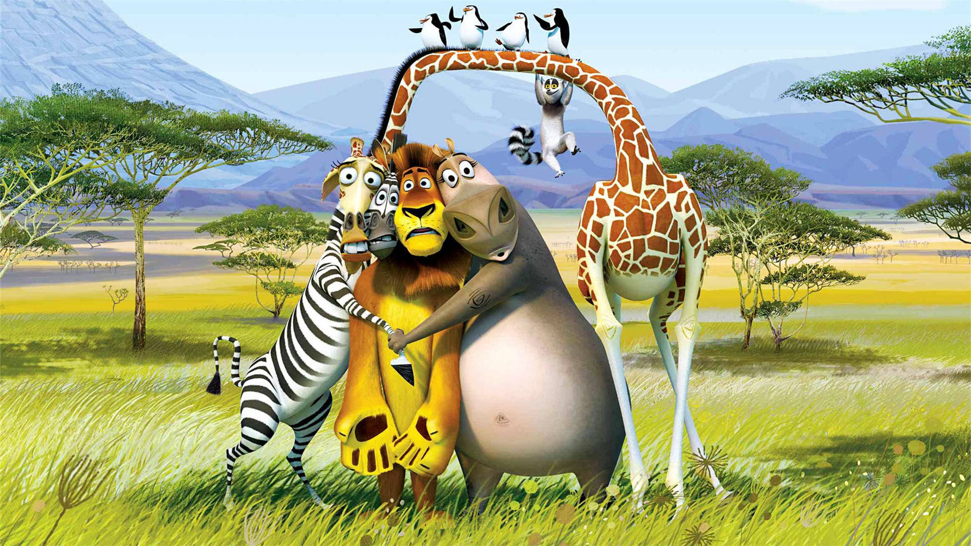 Madagascar 桌布 壁紙 — 動畫動物朋友在充滿活力的非洲稀樹草原上擁抱，背景有山脈和金合歡樹，天空晴朗。