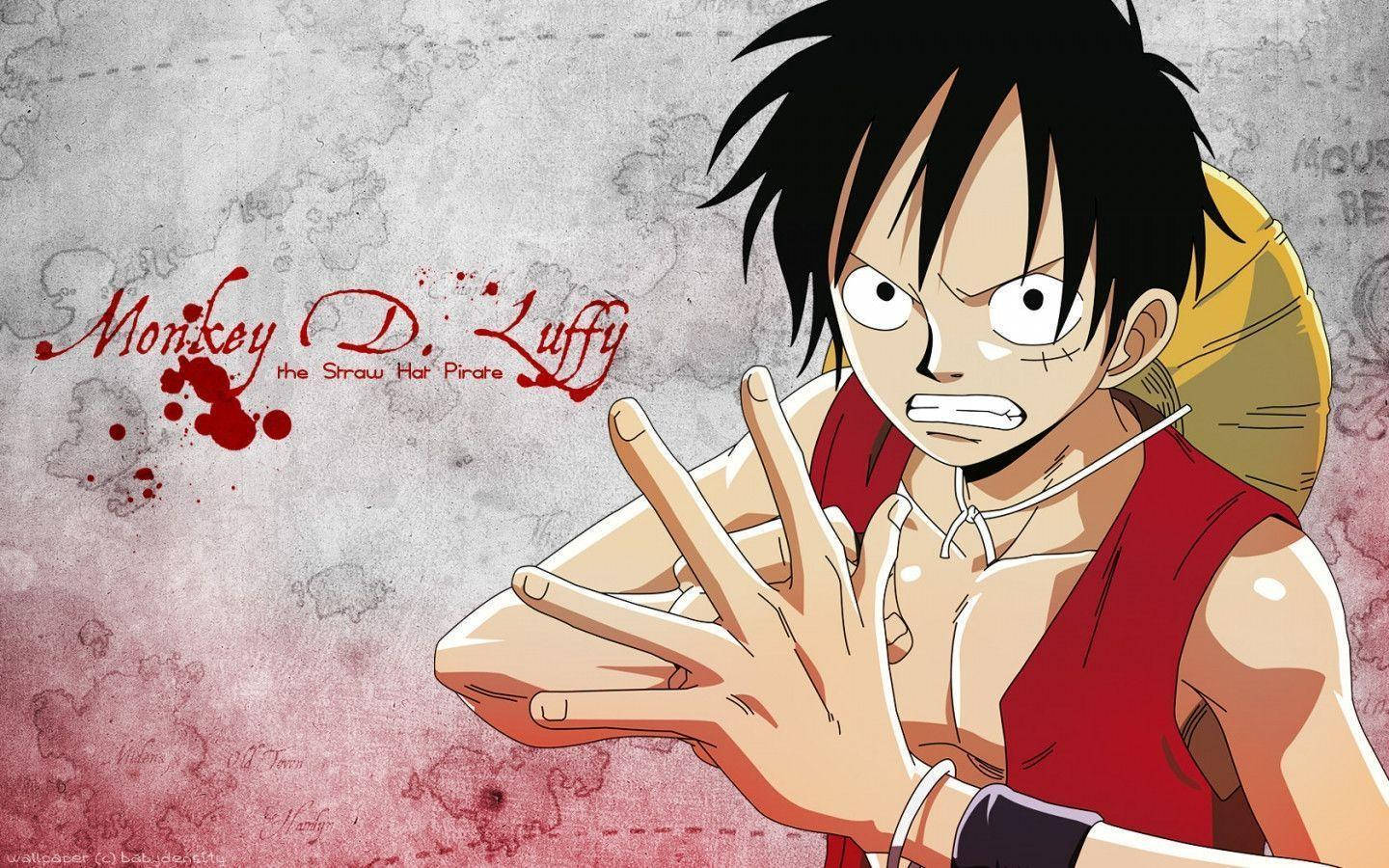Luffy 桌布 壁紙 — 動畫海賊魯夫穿著紅色背心，在紋理粗糙的背景前做出堅定的手勢，他的名字以紅色飛濺文字呈現。