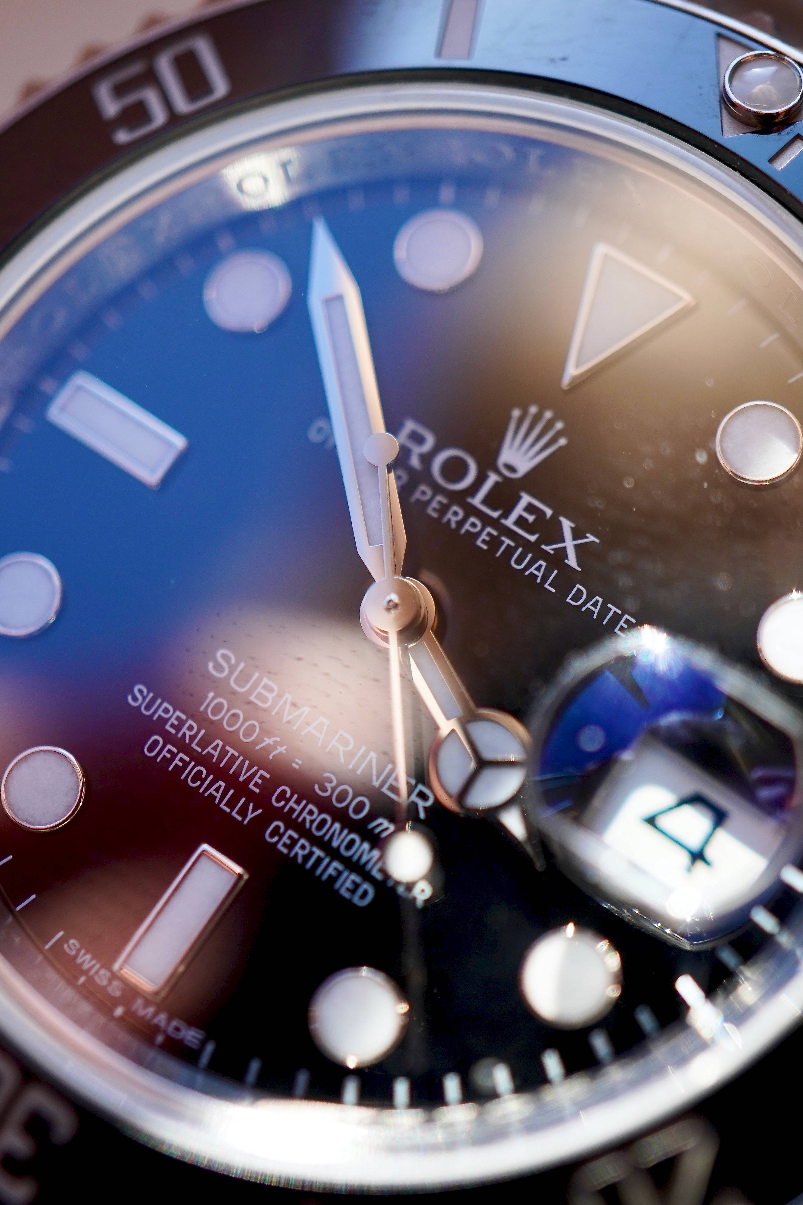 Rolex 桌布 壁紙 — 勞力士Submariner手錶錶盤特寫，藍色漸變錶盤，在暖光下帶有夜光標記。