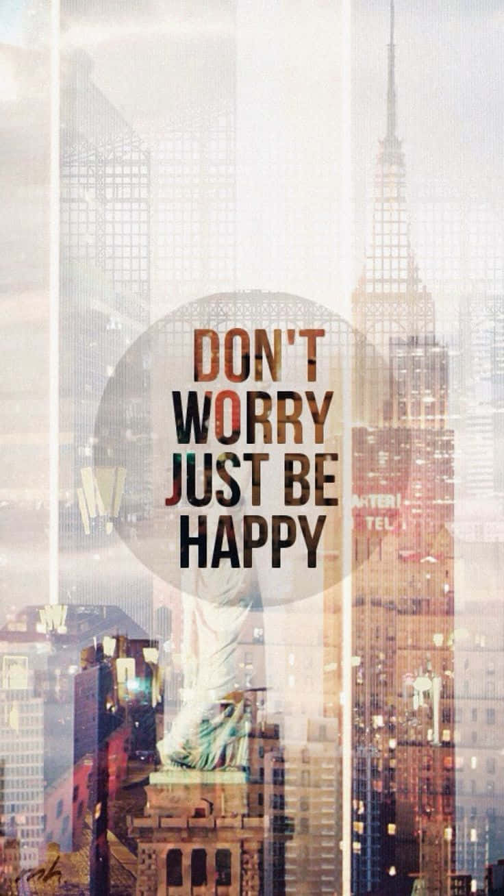 Dont Worry Be Happy 桌布 壁紙 — 勵志文字疊加在朦朧的紐約市天際線上，自由女神像和帝國大廈清晰可見。