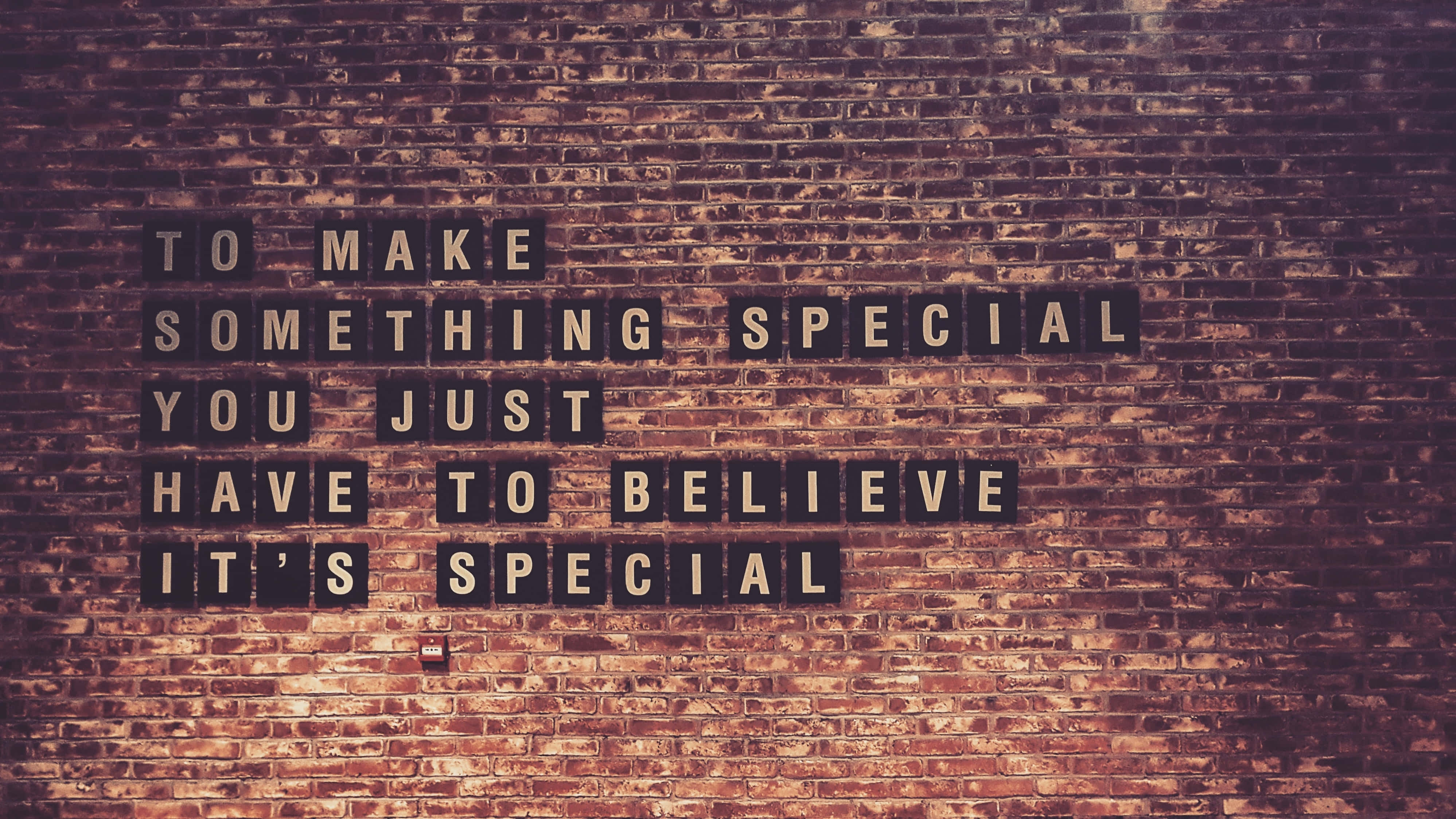 桌布 壁紙 — 勵志語句瓷磚在風化的磚牆上拼出「to make something special you just have to believe it's special」。