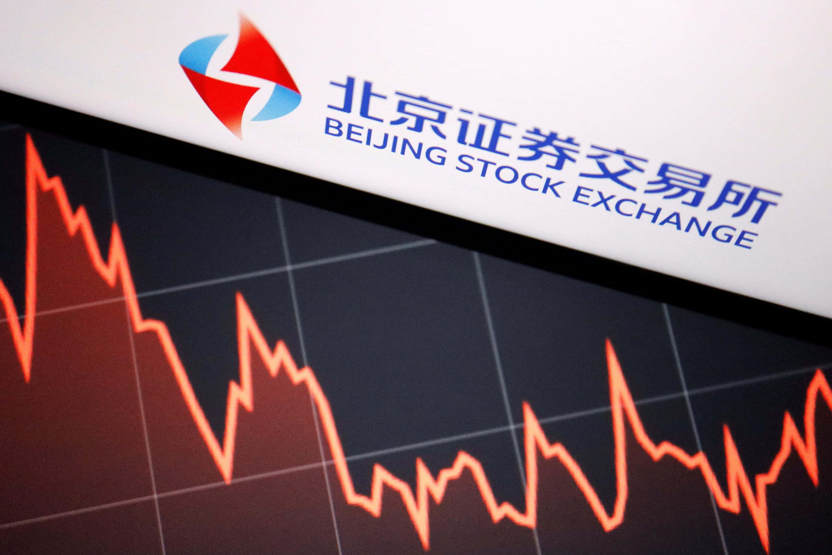 股票 桌布 壁紙 — 北京證券交易所標誌的特寫，位於顯示急劇下跌的紅色股票圖表的螢幕上方。
