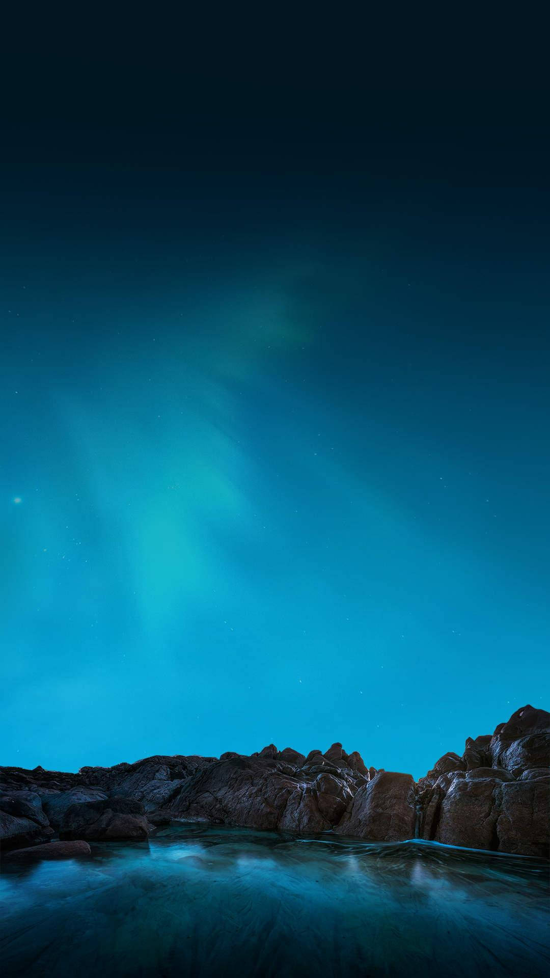 Super 桌布 壁紙 — 北極光在繁星點點的夜空下，在岩石海岸線上舞動著充滿活力的青綠色。