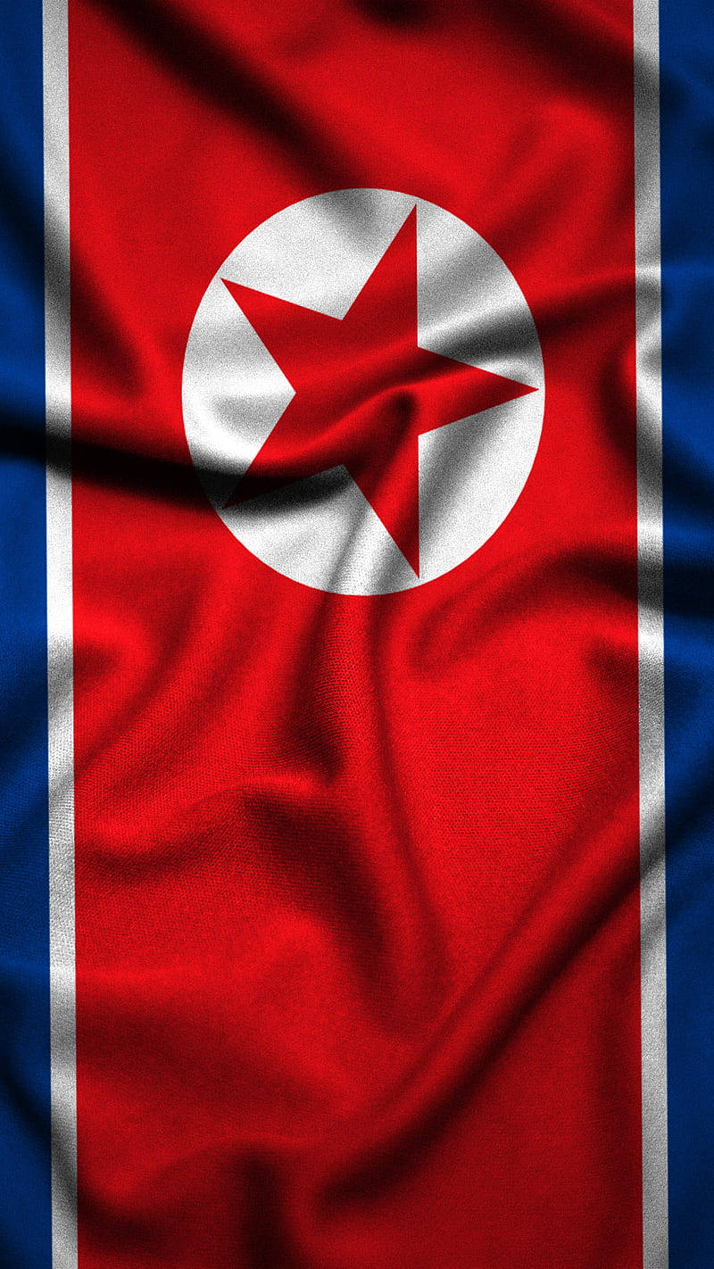 North Korea 桌布 壁紙 — 北韓國旗布料的特寫，有紅、白、藍色條紋，白色圓圈內有一顆紅星。