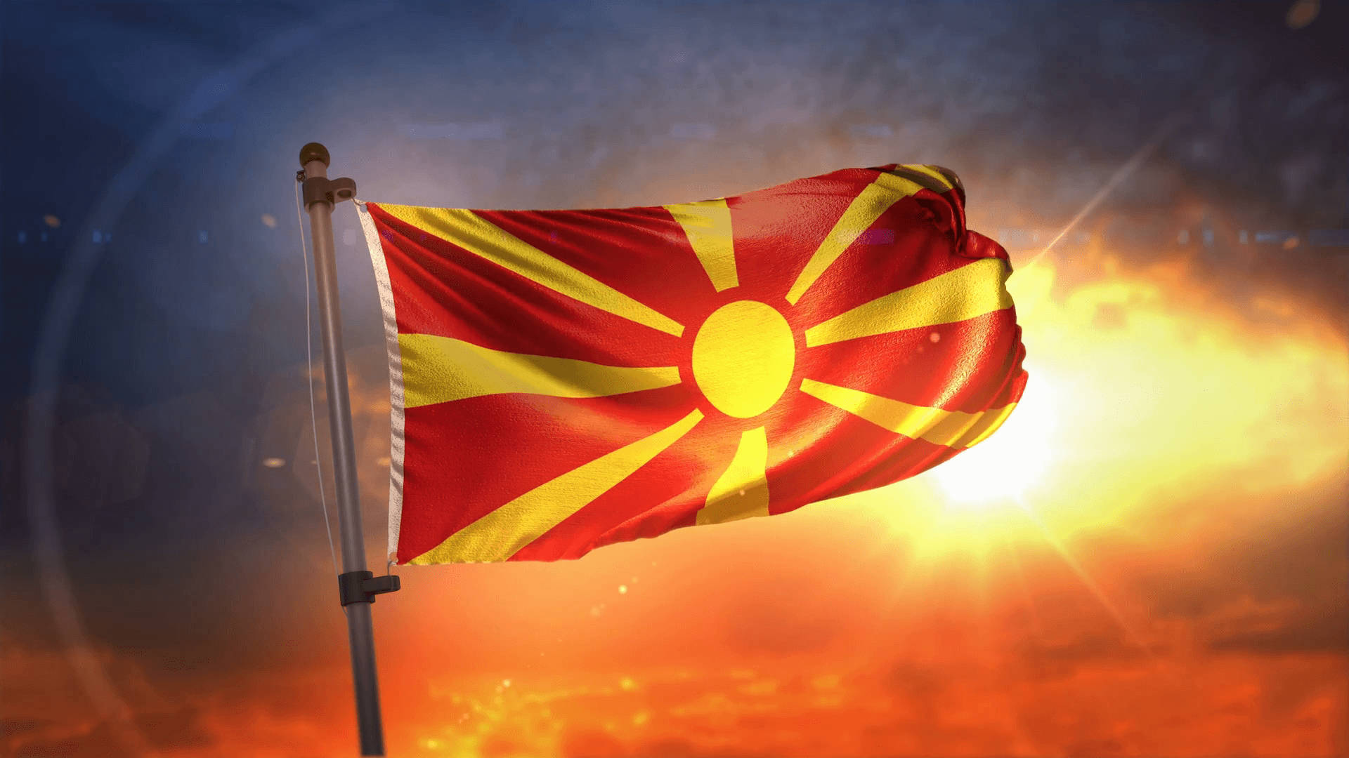 Flag 桌布 壁紙 — 北馬其頓國旗在熾熱的日落天空下自豪地飄揚，伴隨著燦爛的陽光和發光的雲彩。