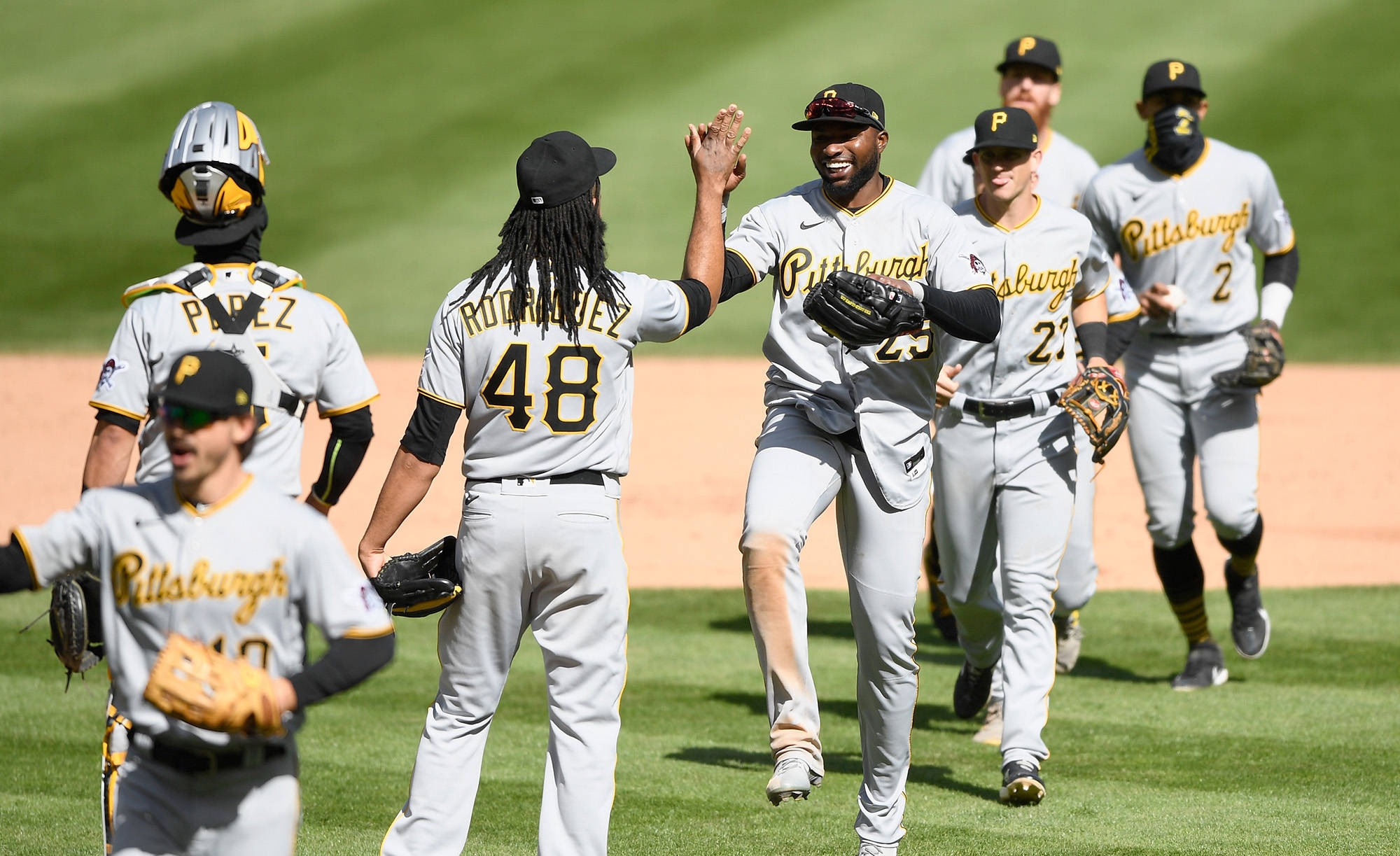 Pittsburgh Pirates 桌布 壁紙 — 匹茲堡棒球球員在陽光明媚的球場上擊掌慶祝，面露喜悅。