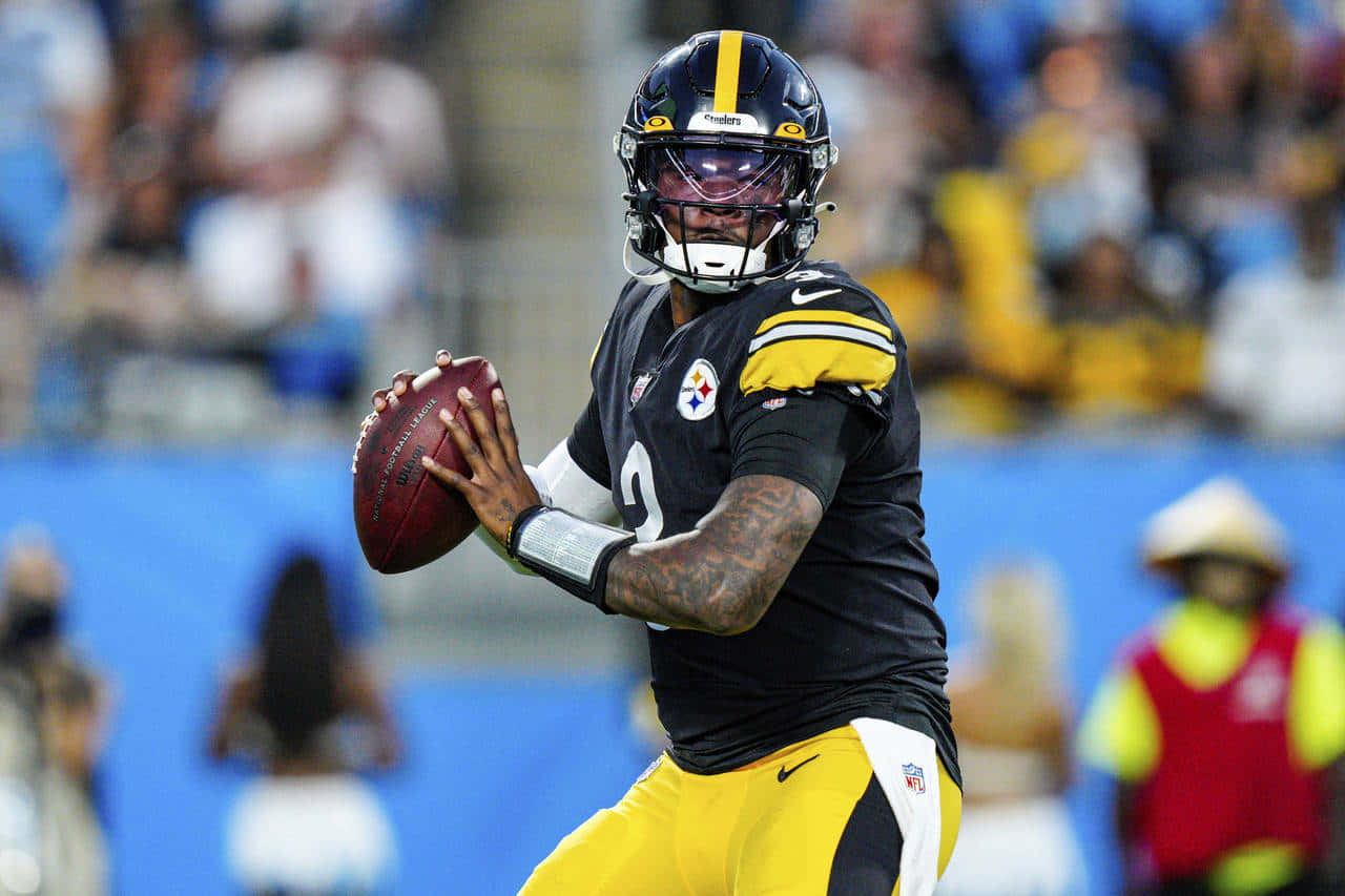 Dwayne Haskins 桌布 壁紙 — 匹茲堡鋼人隊的四分衛身穿黑色和金色制服，在體育場燈光下準備在比賽中擲出橄欖球。
