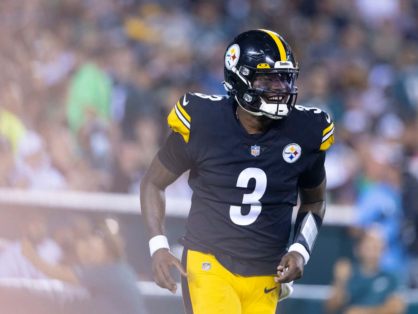 Dwayne Haskins 桌布 壁紙 — 匹茲堡鋼人隊的美式足球員身穿黑金色制服，在夜間比賽的球場燈光下全力奔跑。