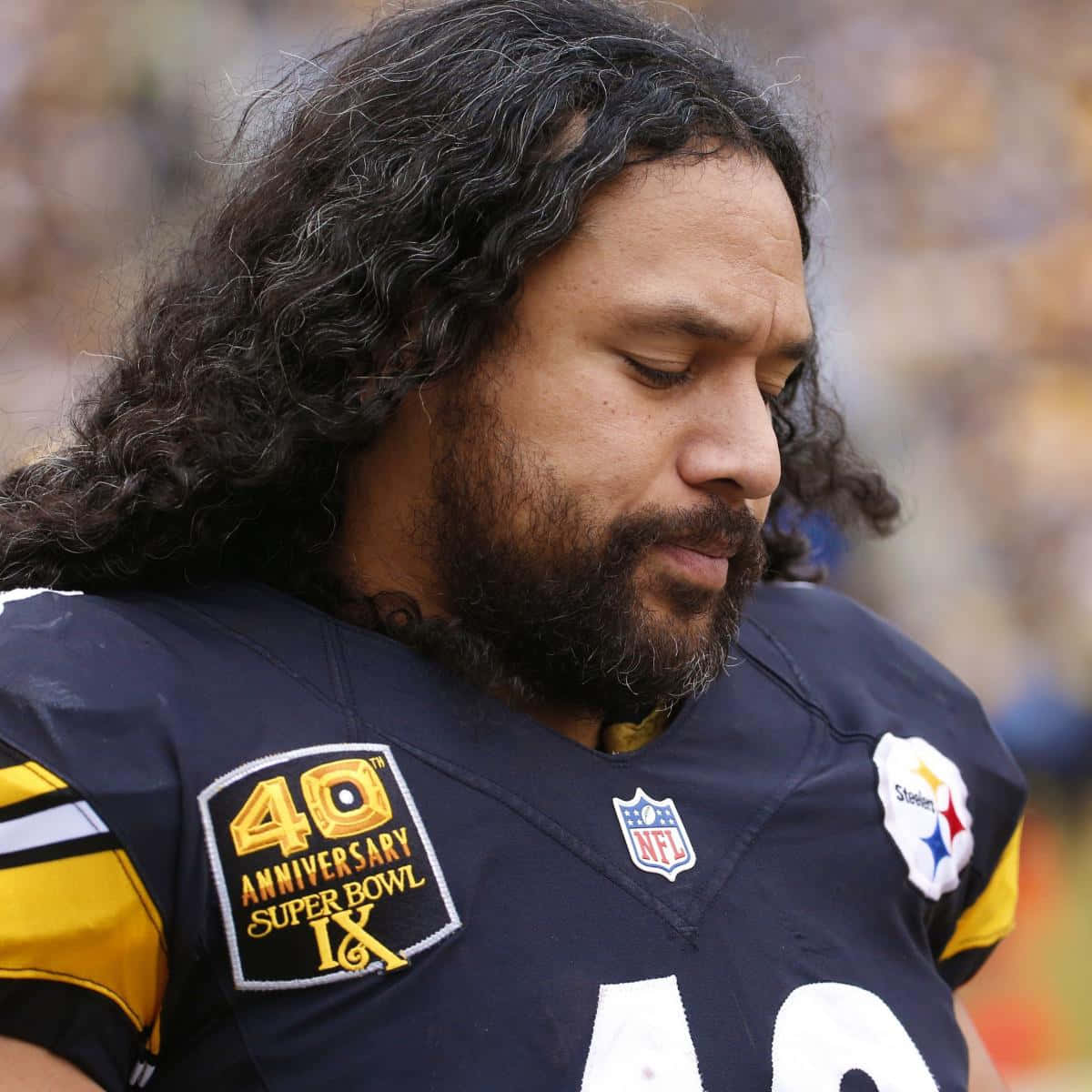 Troy Polamalu 桌布 壁紙 — 匹茲堡鋼人隊美式足球員的近距離特寫，長黑髮和鬍鬚，低頭注視，焦點清晰。