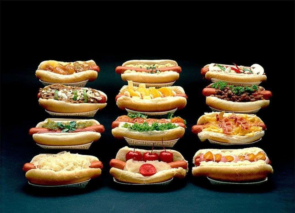 Delicious Food 桌布 壁紙 — 十二款美食熱狗配上多種配料，在深色背景上以網格排列。