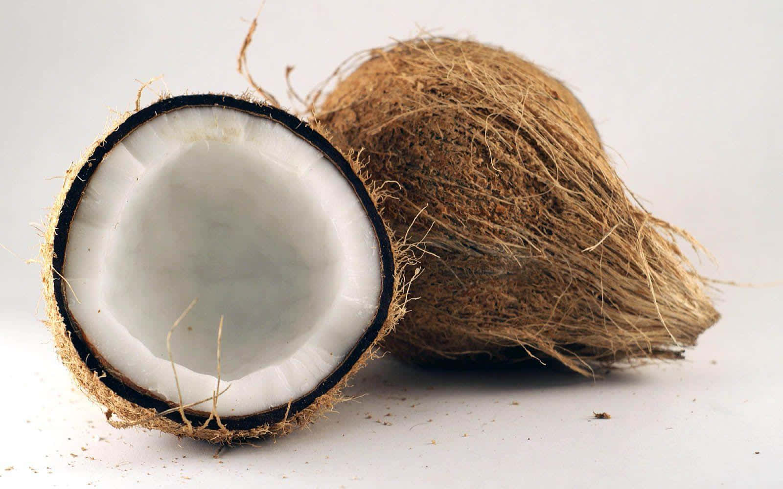 Coconut 桌布 壁紙 — 半個椰子露出白色果肉，放在純白色背景上，外殼放在旁邊。