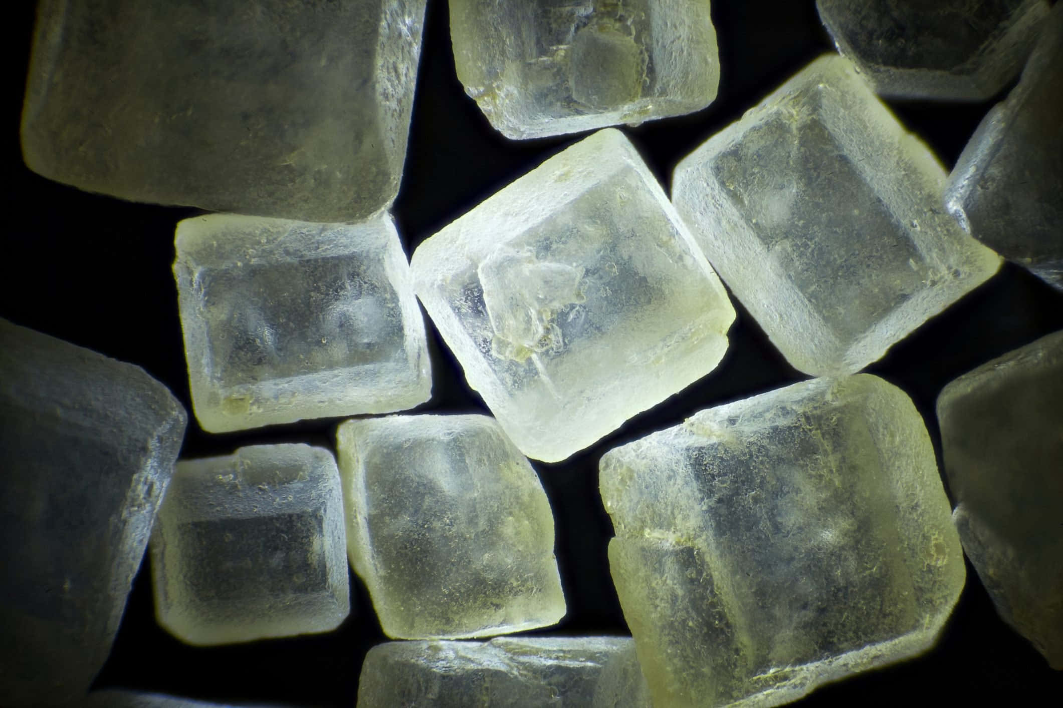cubes 桌布 壁紙 — 半透明淡黃色糖晶體在黑色背景上發光的特寫。
