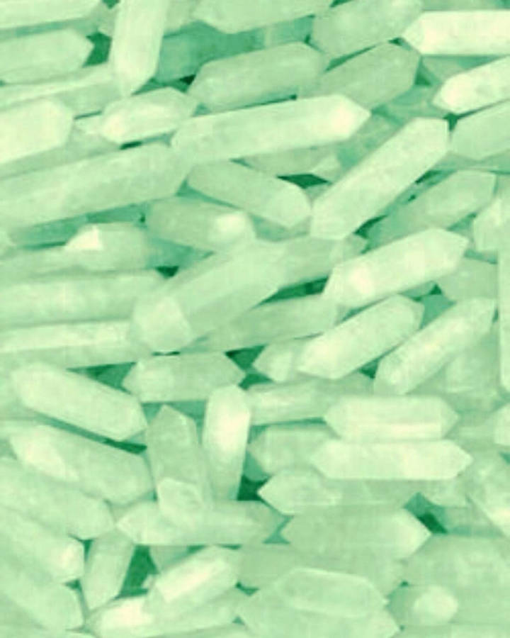 水晶 桌布 壁紙 — 半透明薄荷綠色水晶棒散落在柔和發光圖案中的特寫。