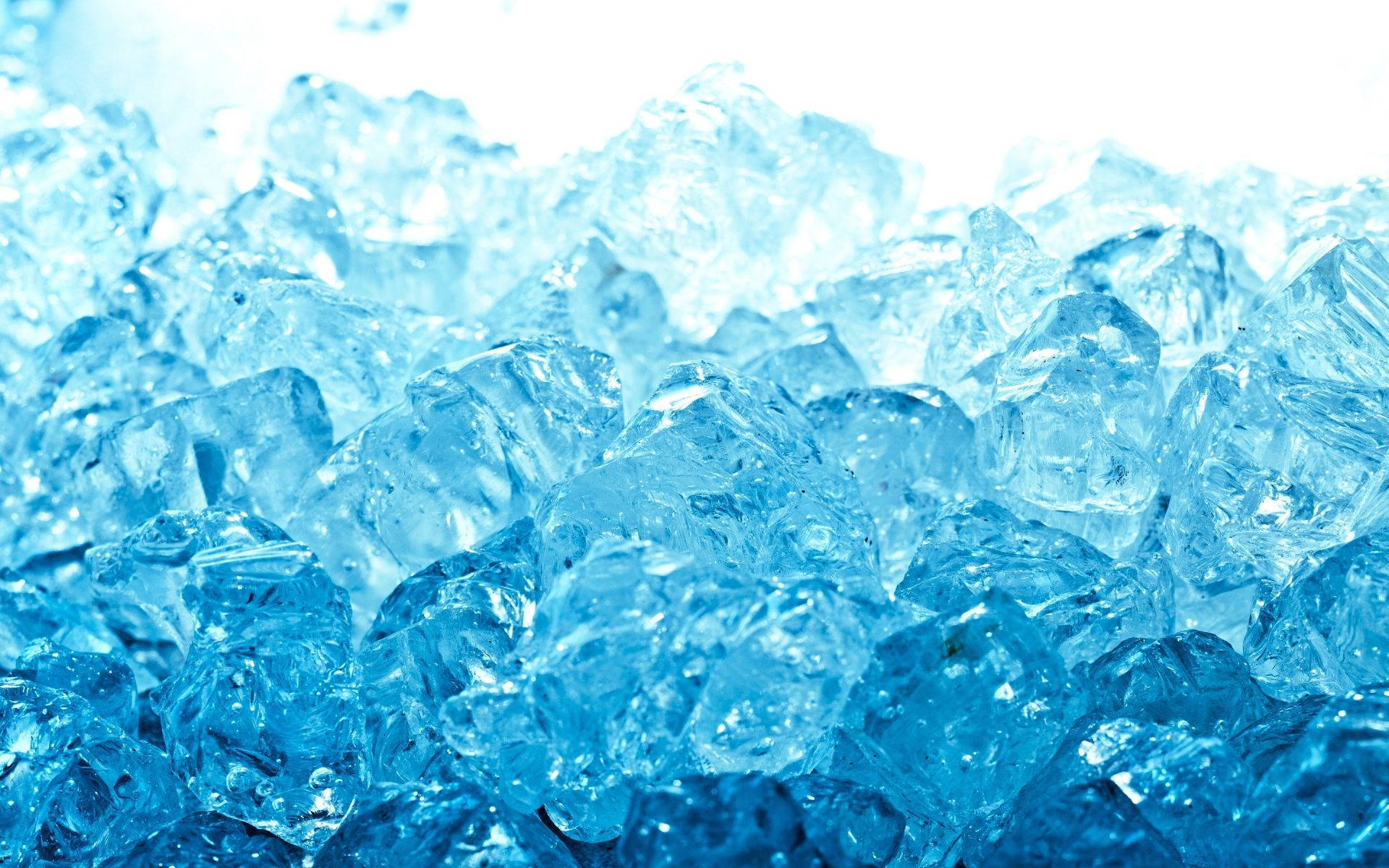 冰 桌布 壁紙 — 半透明藍色冰塊的特寫，閃爍著銳利的切面和冷光。