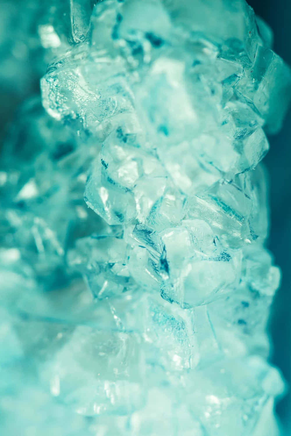 Turquoise Green 桌布 壁紙 — 半透明青綠色冰晶的特寫，閃爍著銳利的切面與柔和散景背景。