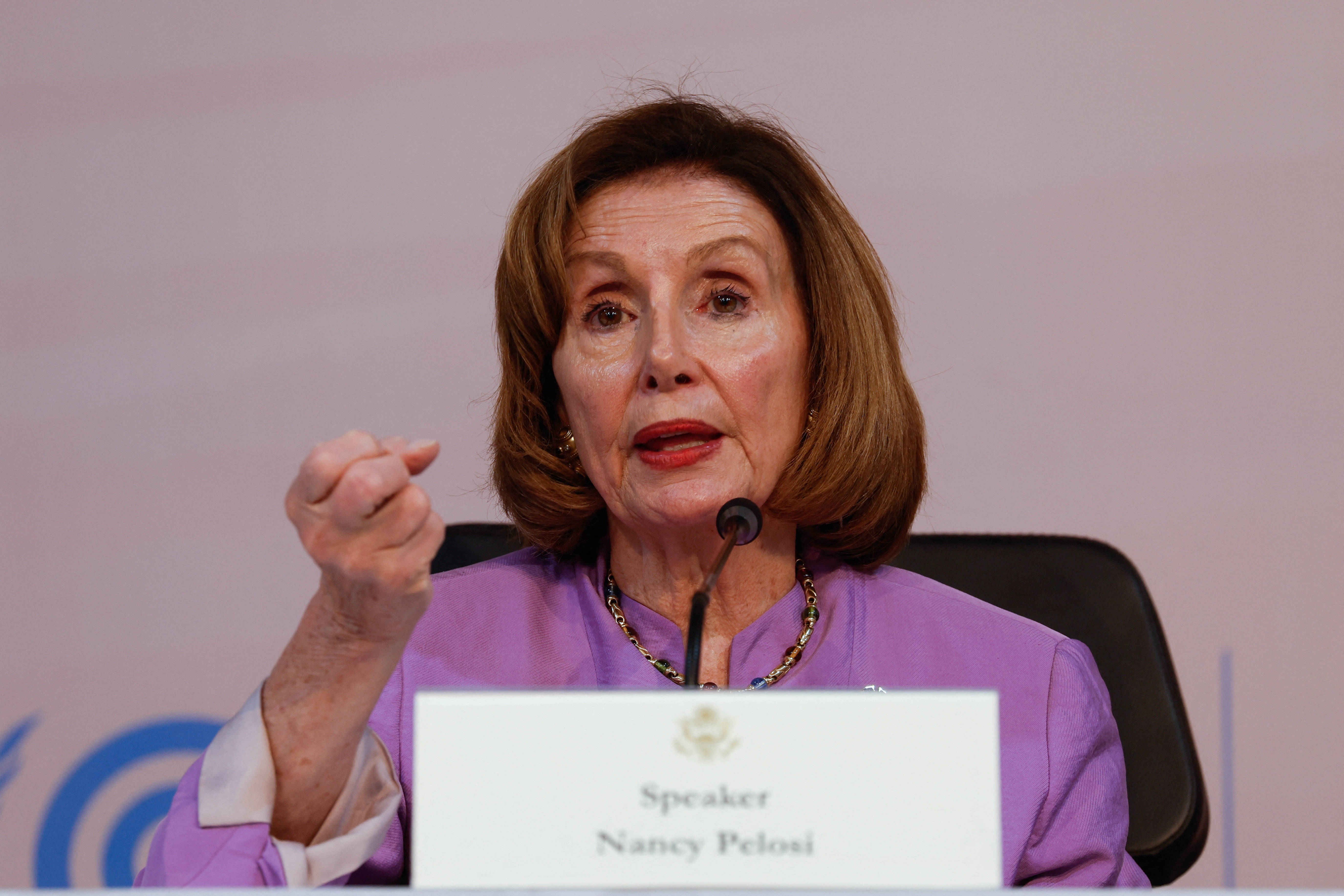Nancy Pelosi 桌布 壁紙 — 南希·裴洛西在正式活動中發言，身穿紫色襯衫，右手做手勢。