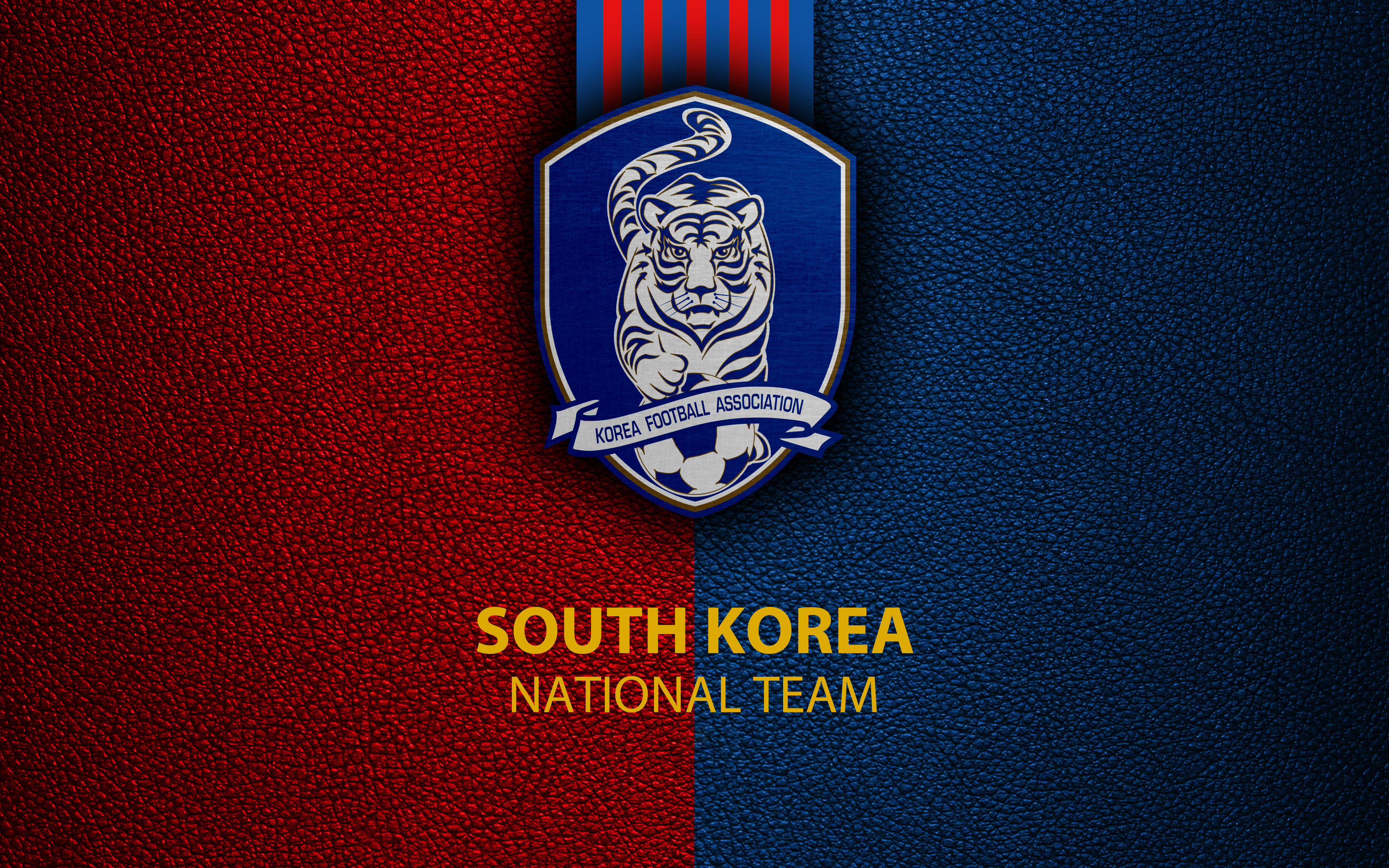 South Korea 桌布 壁紙 — 南韓國家隊徽章，置於帶紋理的紅藍皮革背景上，配以粗體黃色文字。
