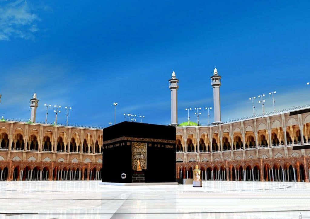 Kaaba 桌布 壁紙 — 卡巴天房莊嚴地矗立在大清真寺中央，上方是清澈的藍天，高聳的宣禮塔和拱形柱廊環繞著廣闊的白色大理石庭院。