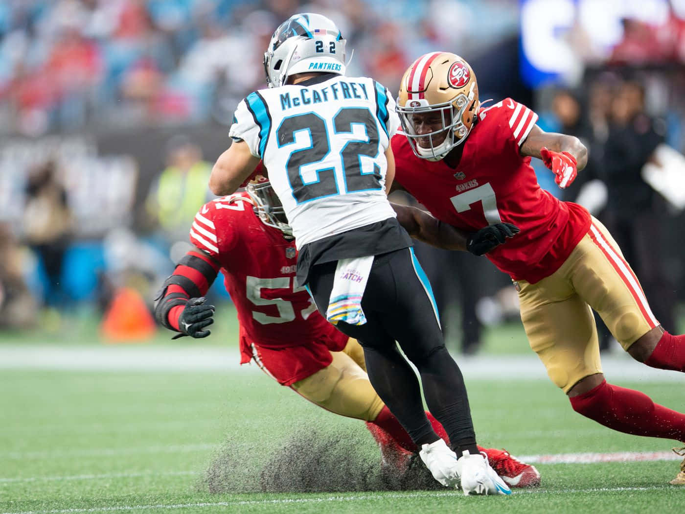 Christian Mccaffrey 桌布 壁紙 — 卡羅萊納黑豹隊的22號跑衛在激烈的NFL比賽中被舊金山49人隊的防守球員擒抱。