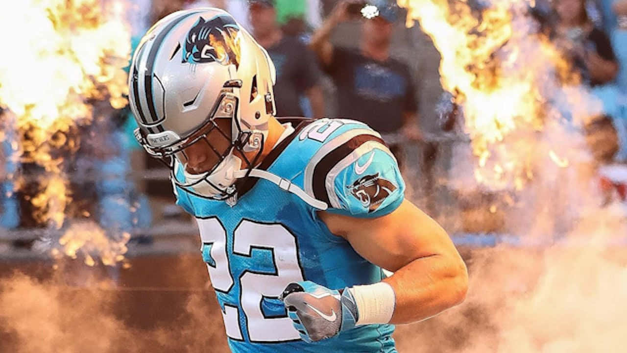 Christian Mccaffrey 桌布 壁紙 — 卡羅萊納黑豹隊的藍色制服美式足球員在比賽中穿過熾熱的煙火。