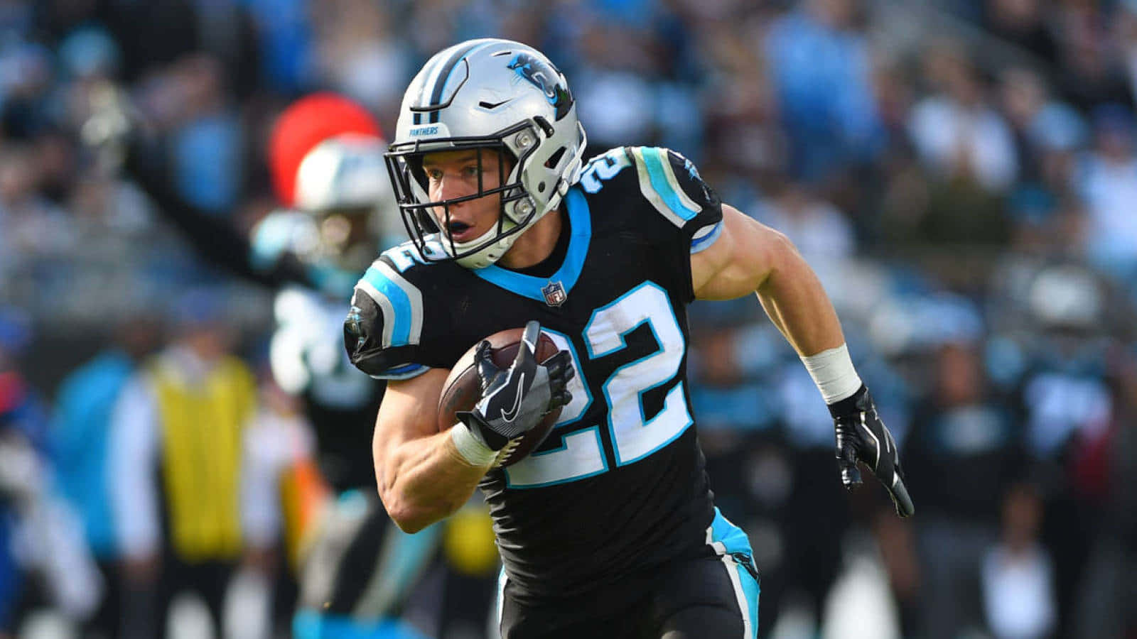 Christian Mccaffrey 桌布 壁紙 — 卡羅萊納黑豹隊的足球員身穿黑藍色制服，在日間比賽中持球衝刺。