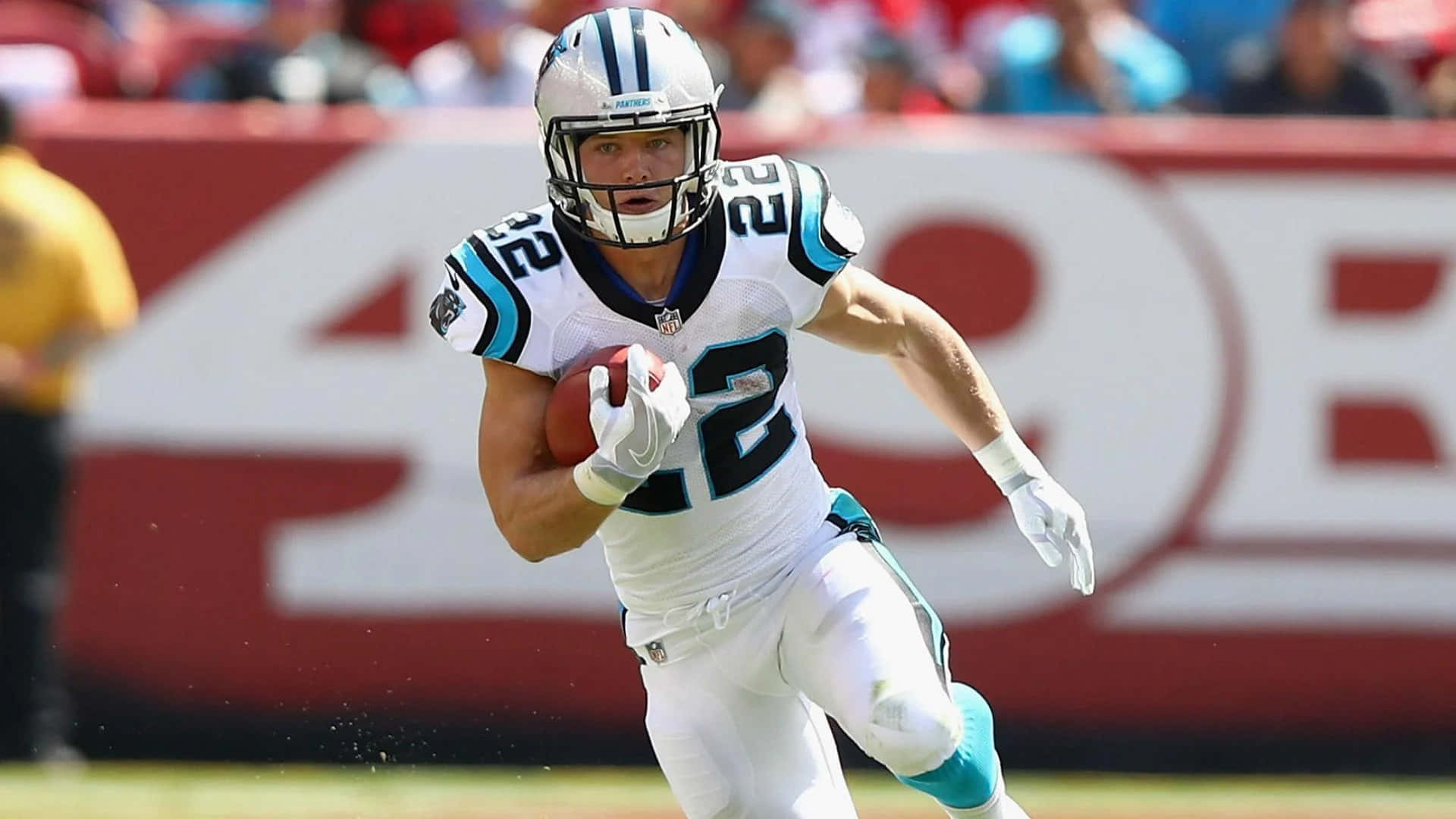 Christian Mccaffrey 桌布 壁紙 — 卡羅萊納黑豹隊美式足球員身穿白色和青綠色球衣，在日間比賽中持球衝刺。