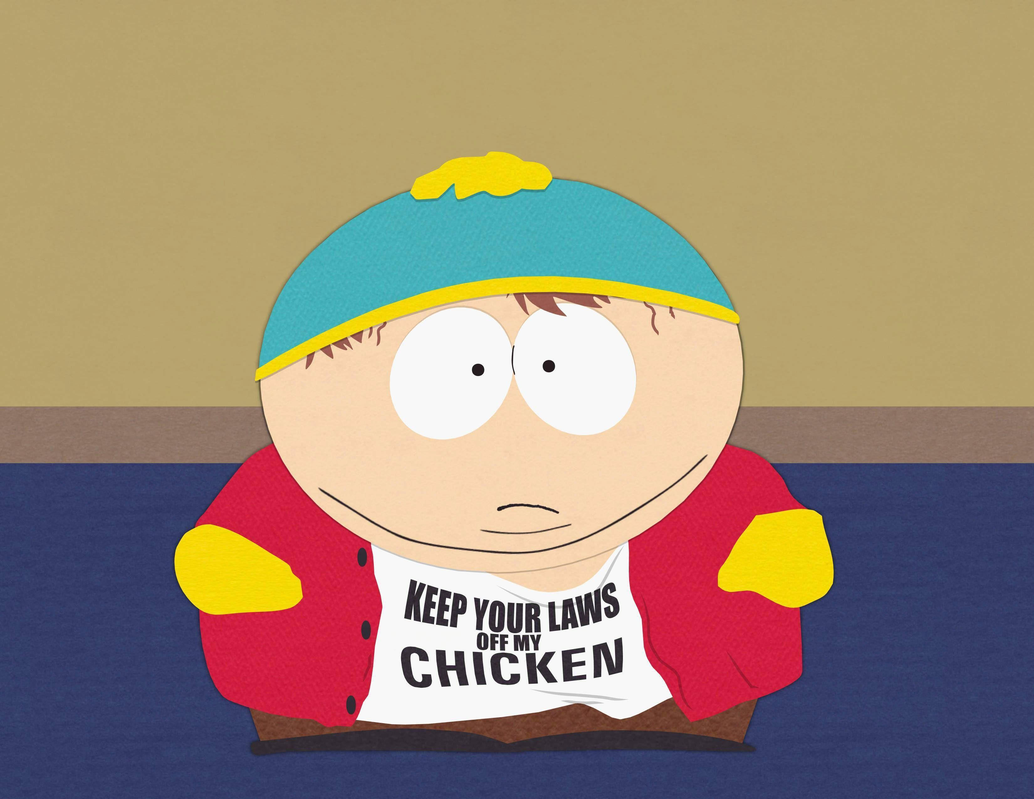 Cartman 桌布 壁紙 — 卡通男孩戴著藍色帽子和紅色外套，穿著印有 keep your laws off my chicken 的襯衫，茫然地凝視著。