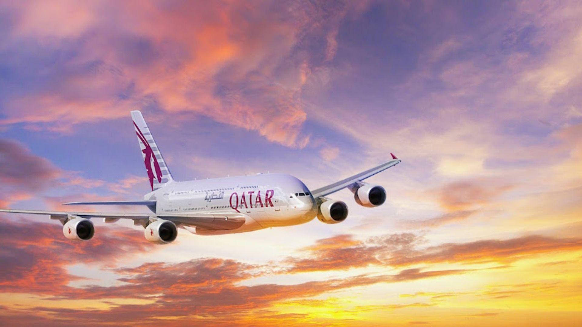 日落 桌布 壁紙 — 卡達航空的空中巴士A380在色彩繽紛的夕陽天空中優雅翱翔，天空被火橙色和紫色的雲彩渲染。