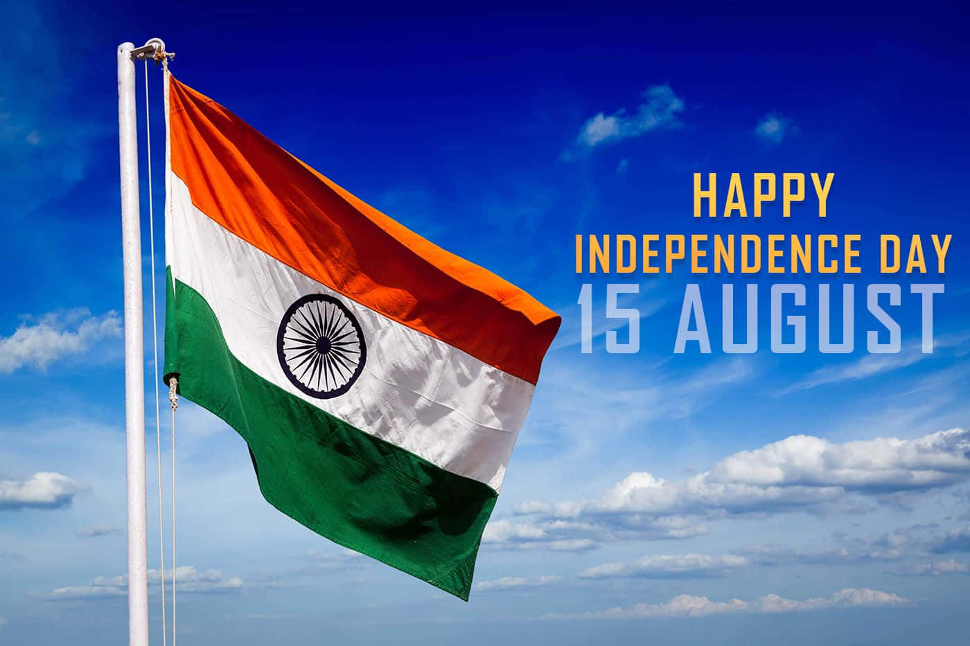 Independence Day 桌布 壁紙 — 印度三色旗在明亮的藍天、蓬鬆的白雲和粗體慶祝文字中自豪地飄揚。